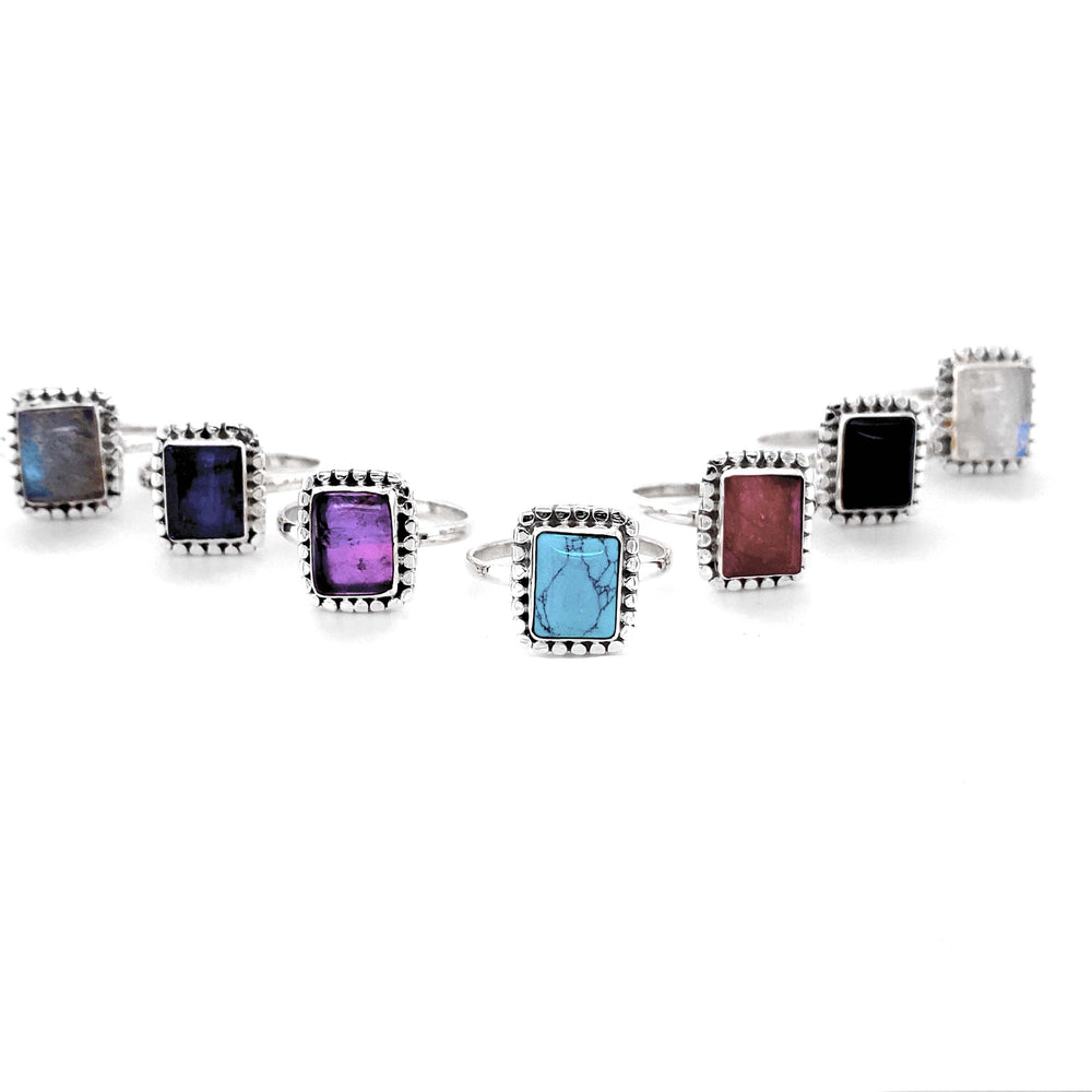 A group of Square Rings with Natural Gemstones on a white background.