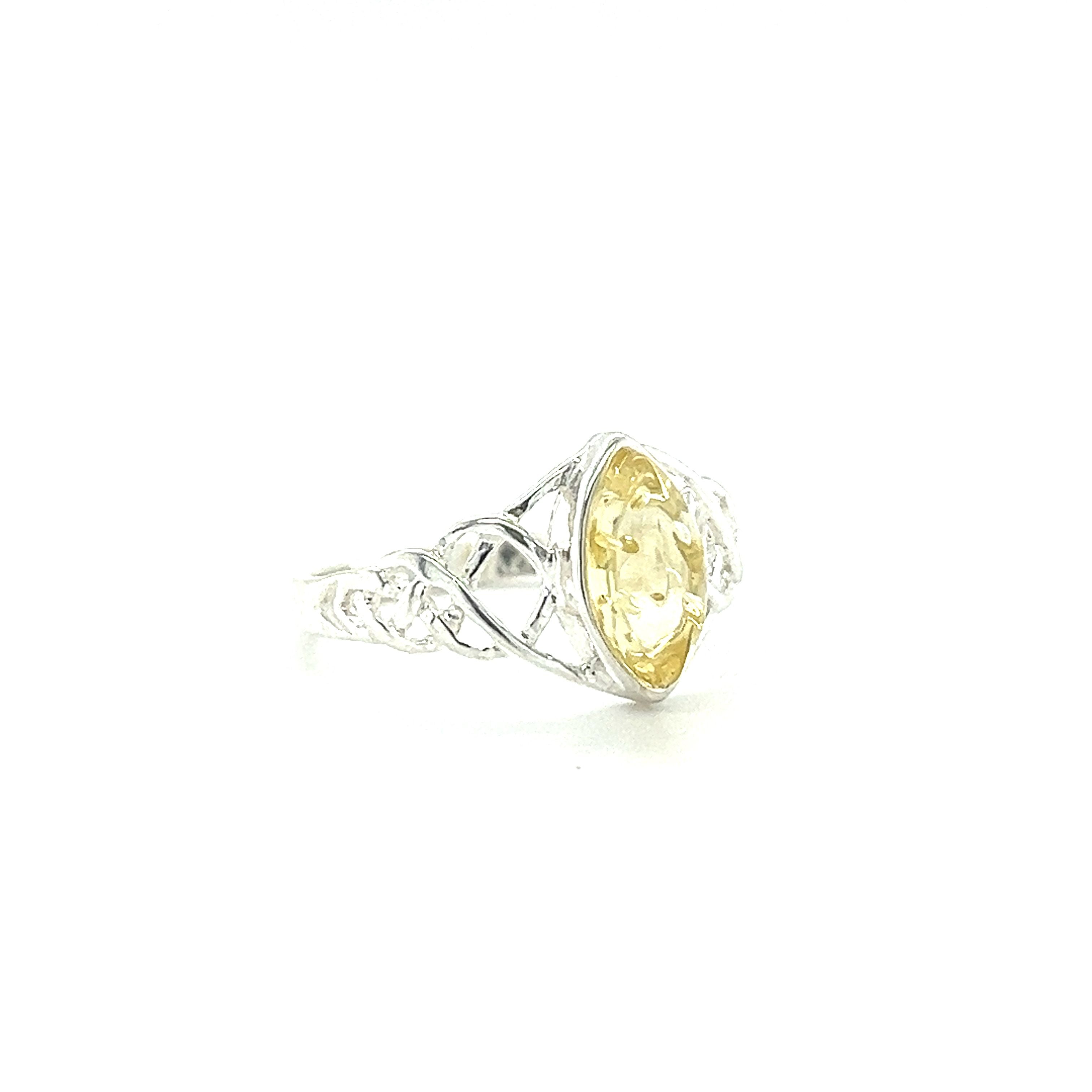 A Baltic Amber Marquise Shaped Celtic Style Ring with a woven band and a yellow citrine stone, made by Super Silver.
