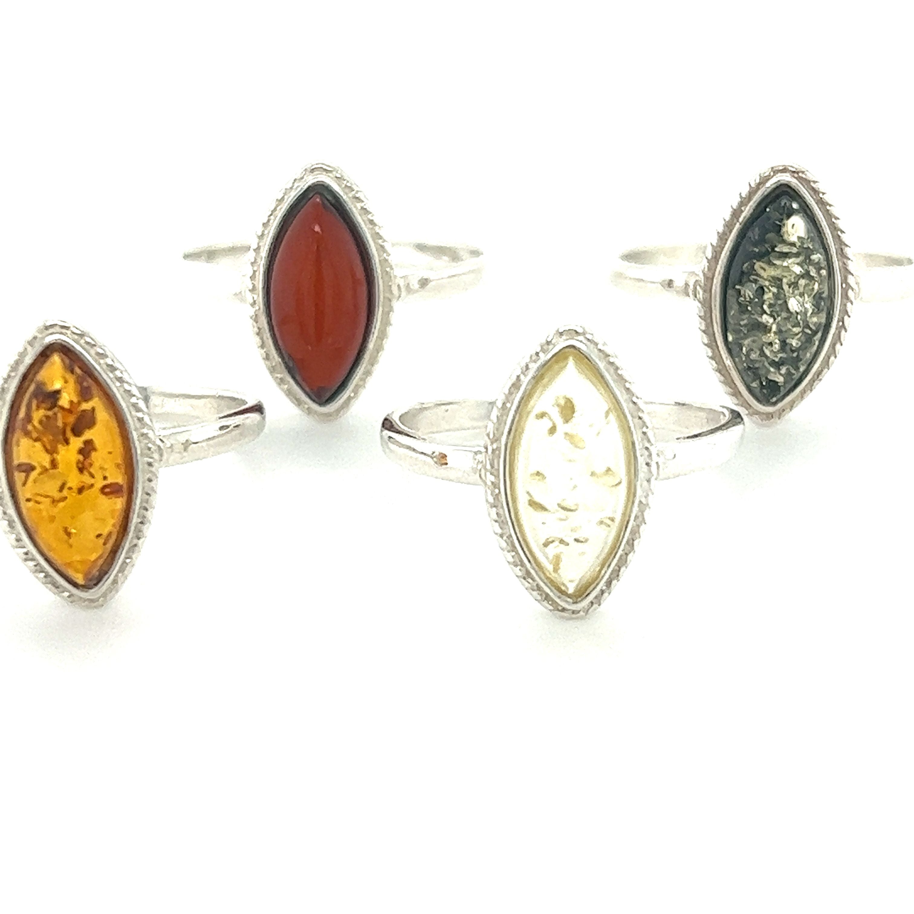 An exquisite collection of Marquise Baltic Amber Rings with Delicate Rope Border featuring amethyst and carnelian stones, elegantly crafted in marquise shapes by Super Silver.
