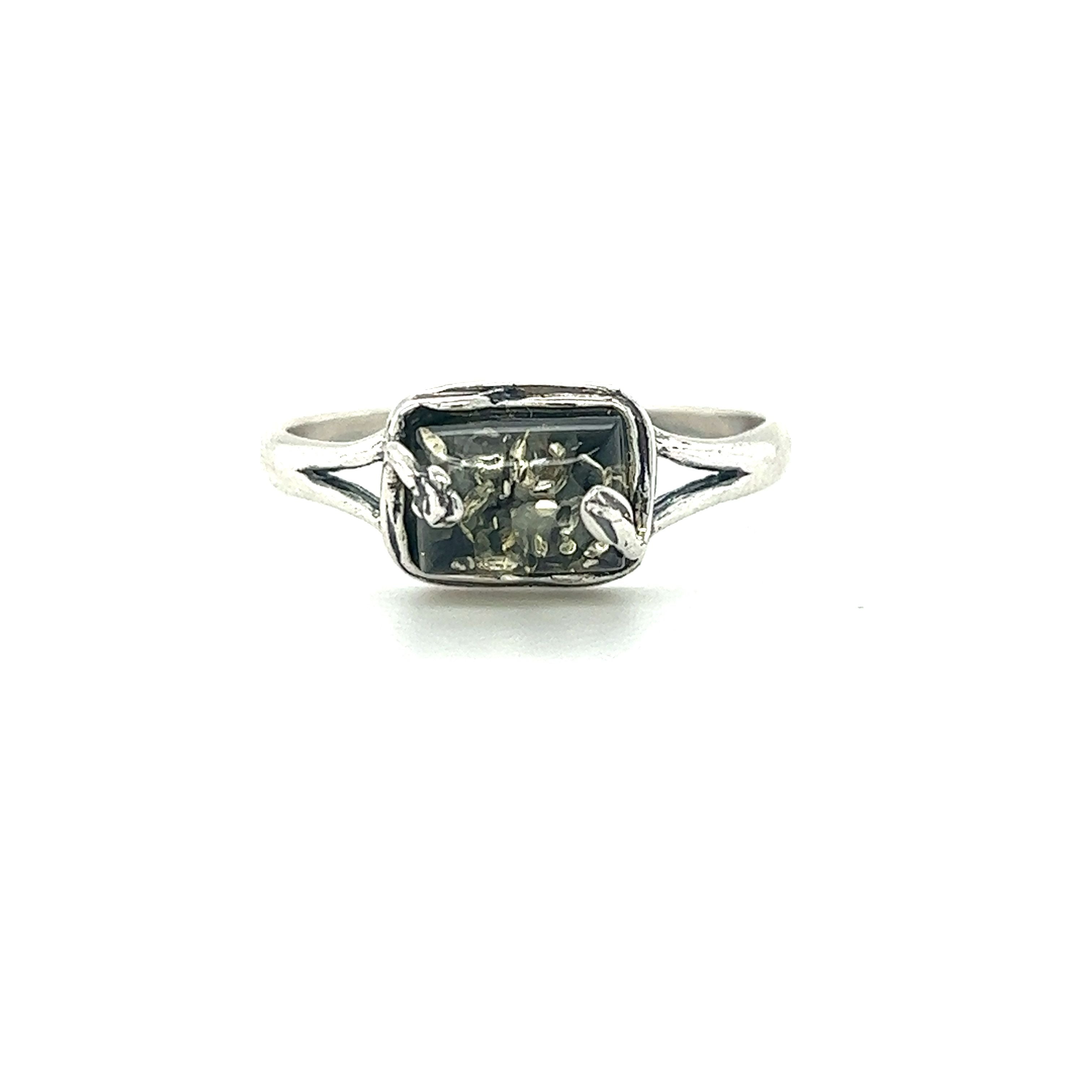 A Super Silver rectangle amber ring with nature detailing in the middle.