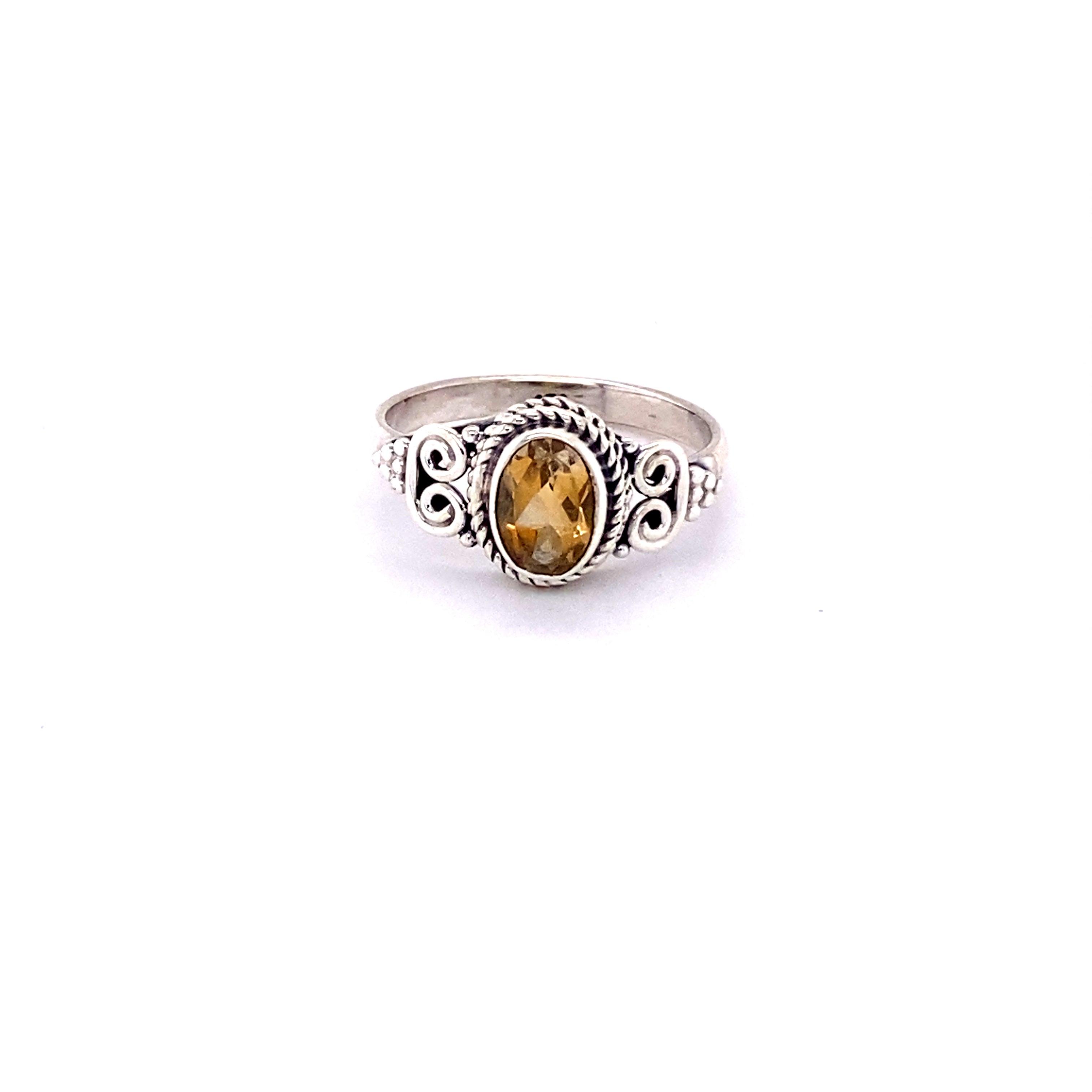 An oval faceted gemstone ring with a swirl design.