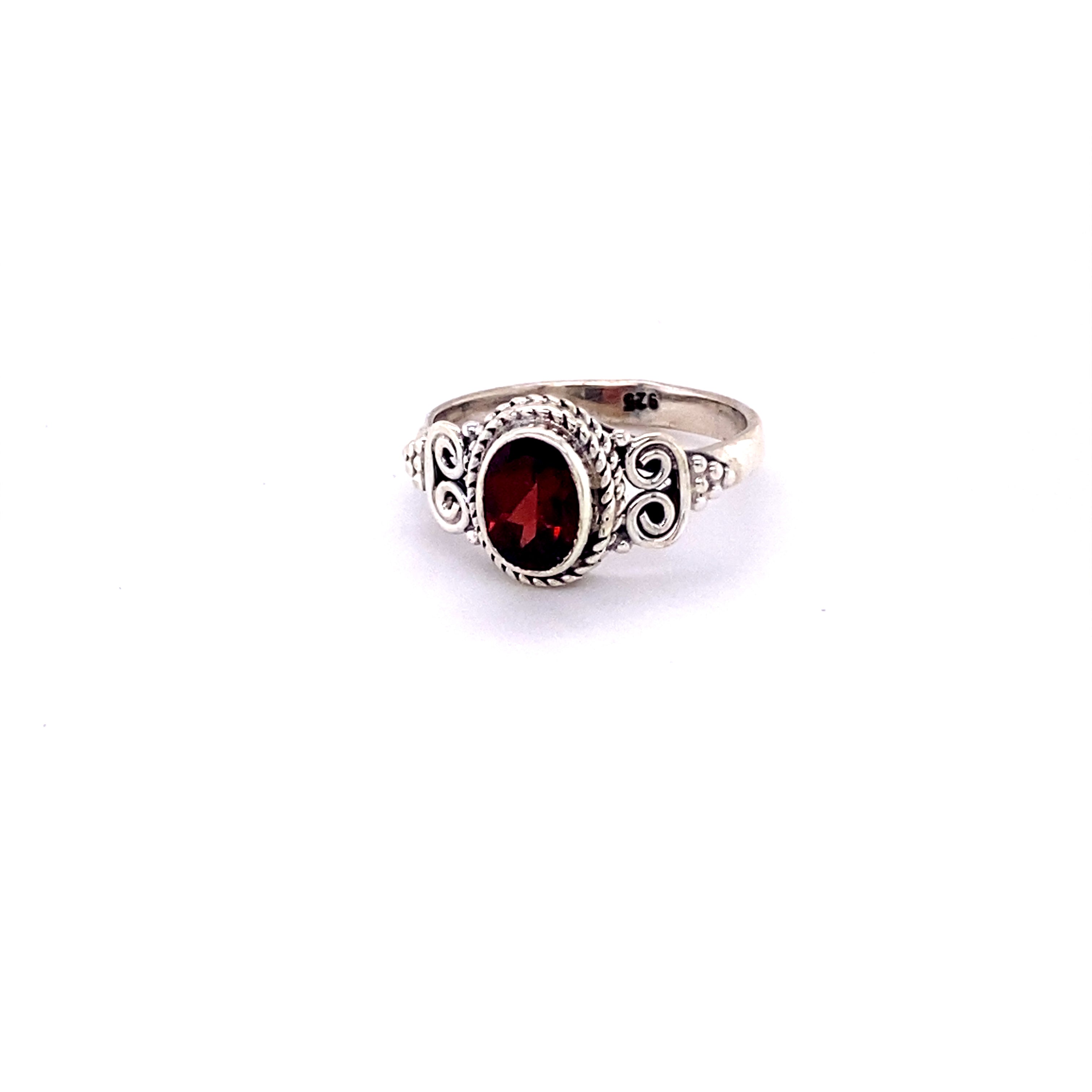 A hippie-inspired Oval Faceted Gemstone Ring with a Swirl Design featuring a stunning cabochon garnet stone.