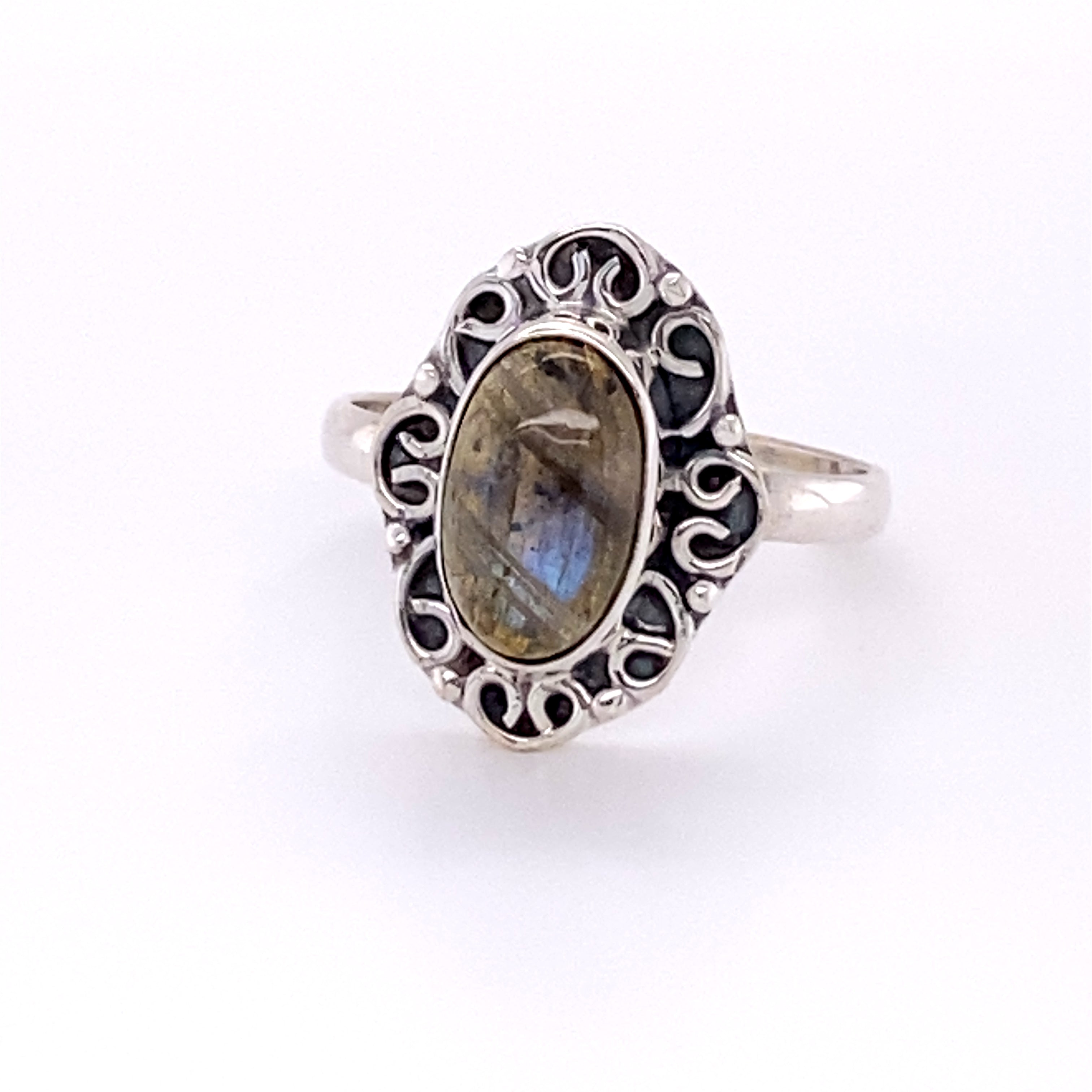 An Oval Gemstone Ring with Swirl Filigree Border with a labradorite cabochon stone.