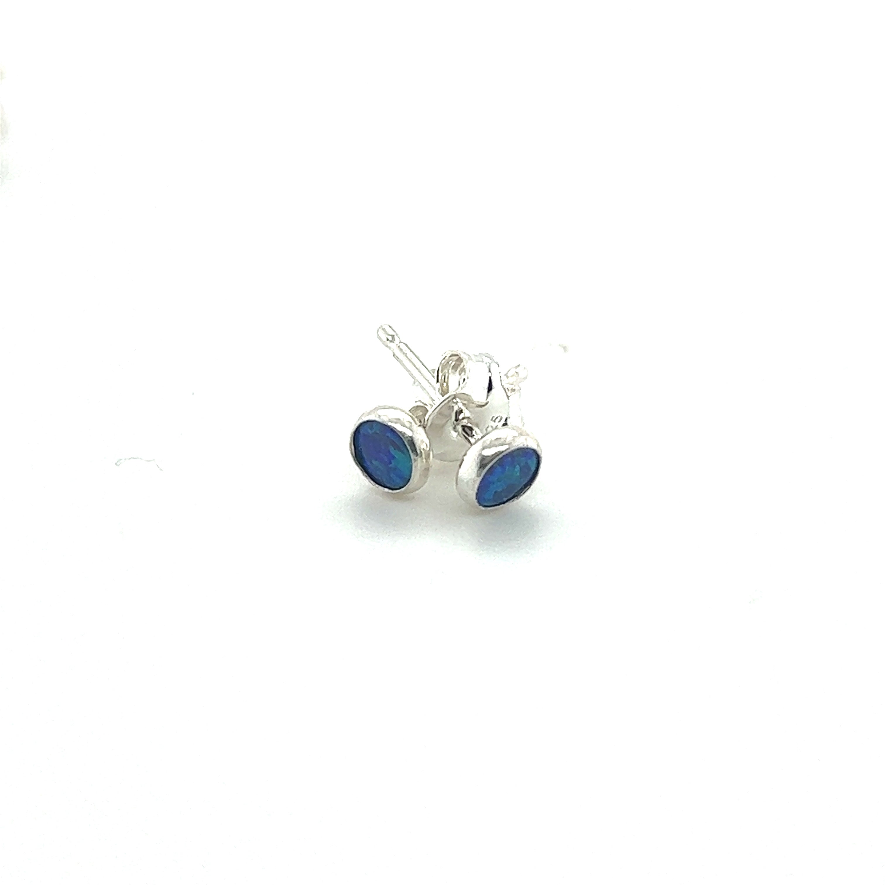 A pair of Super Silver Dainty Opal Studs with minimalist designs on a white surface.