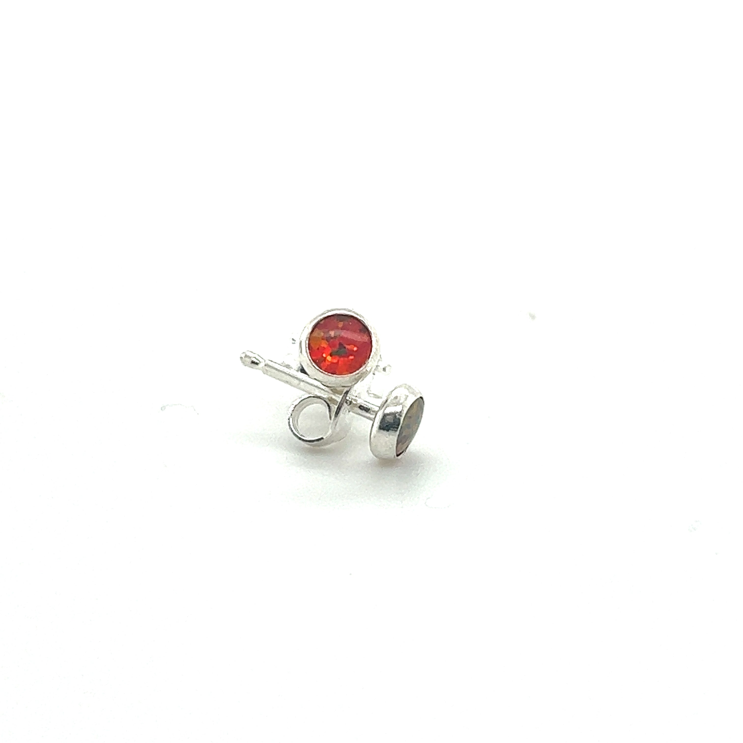A pair of Dainty Opal Studs by Super Silver, with a red stone, perfect for minimalist designs.