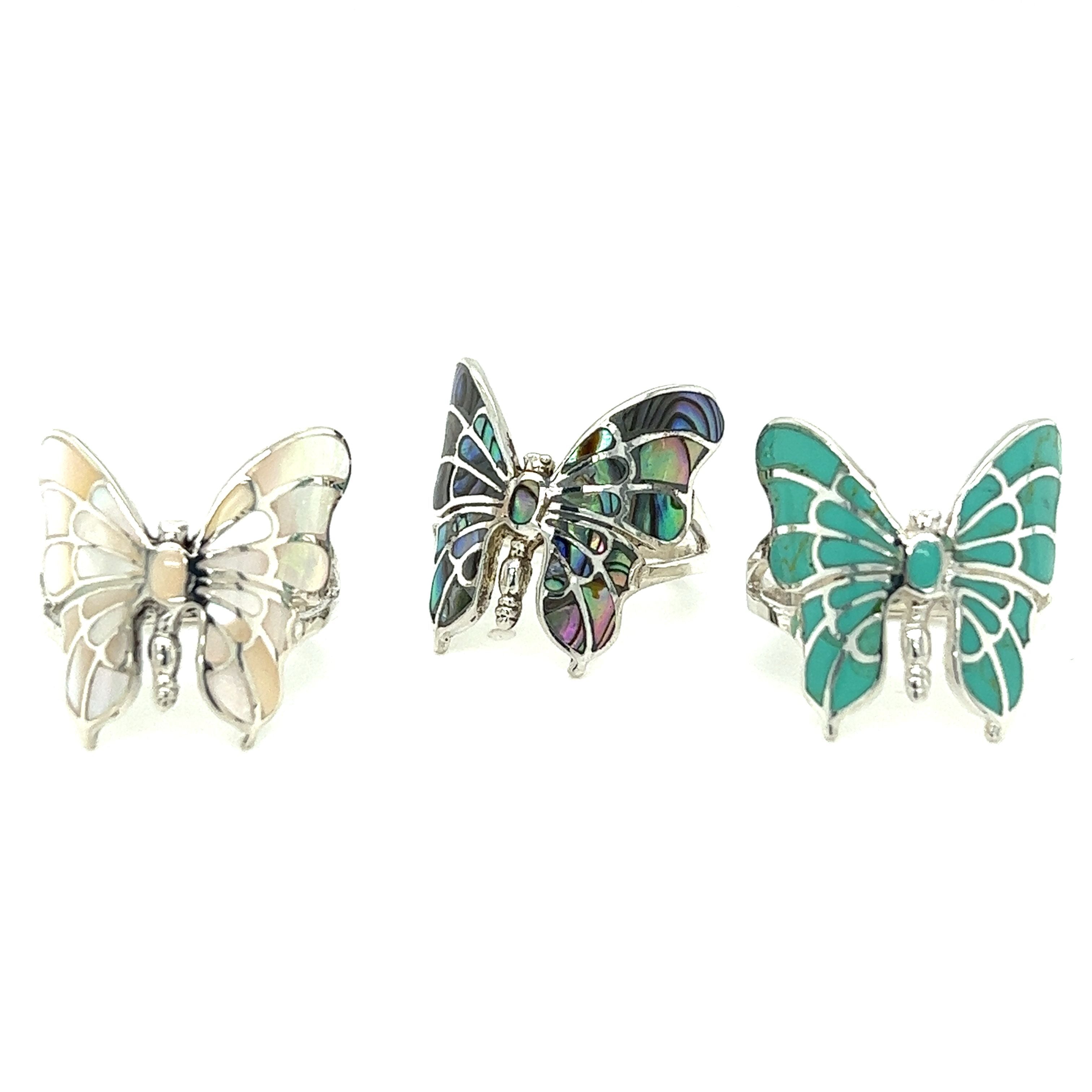Three Intricate Statement Butterfly Inlay Rings with turquoise and mother of pearl stones.