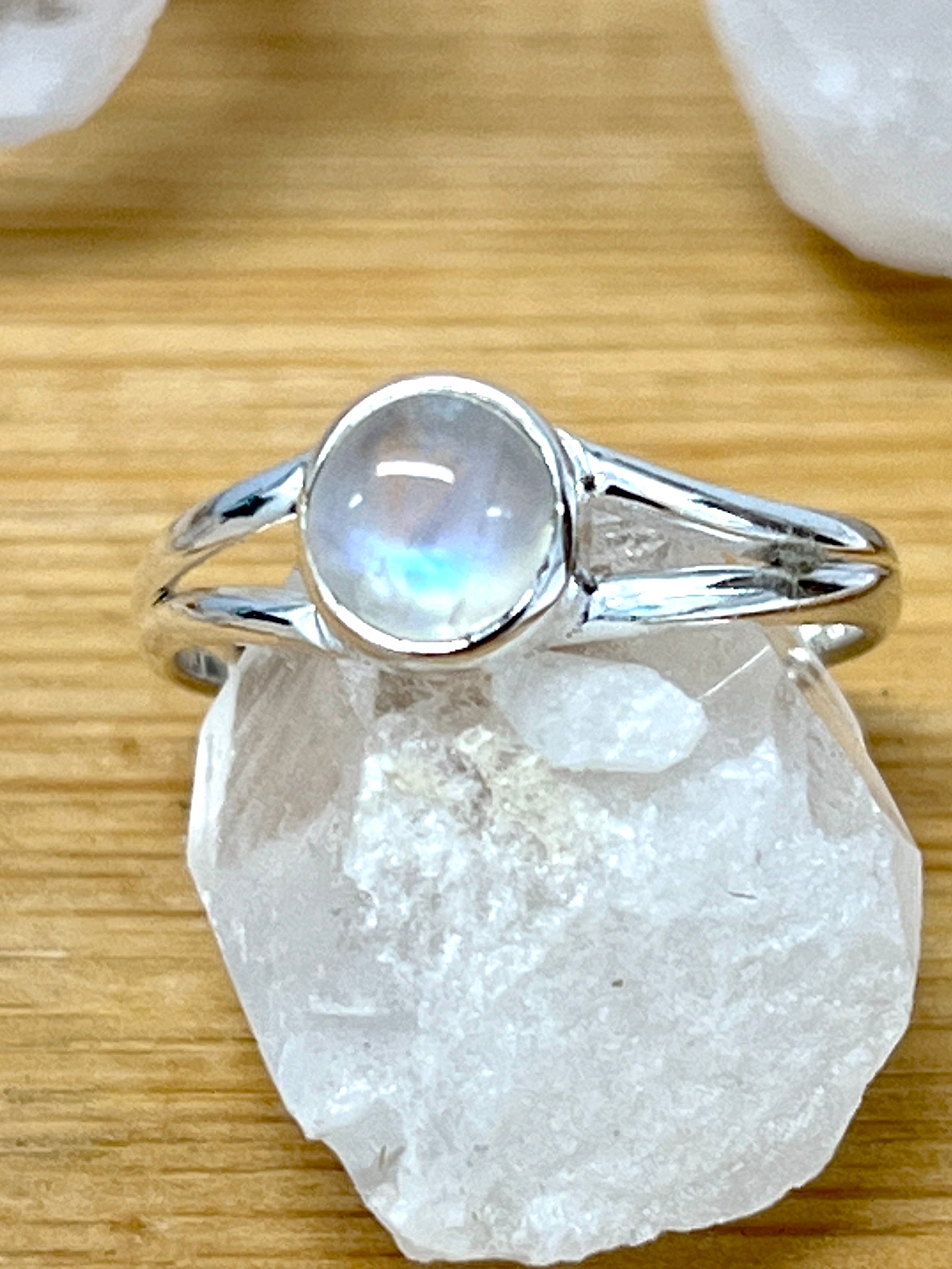 A Circular Minimalist Stone Ring by Super Silver placed delicately atop a rock.
