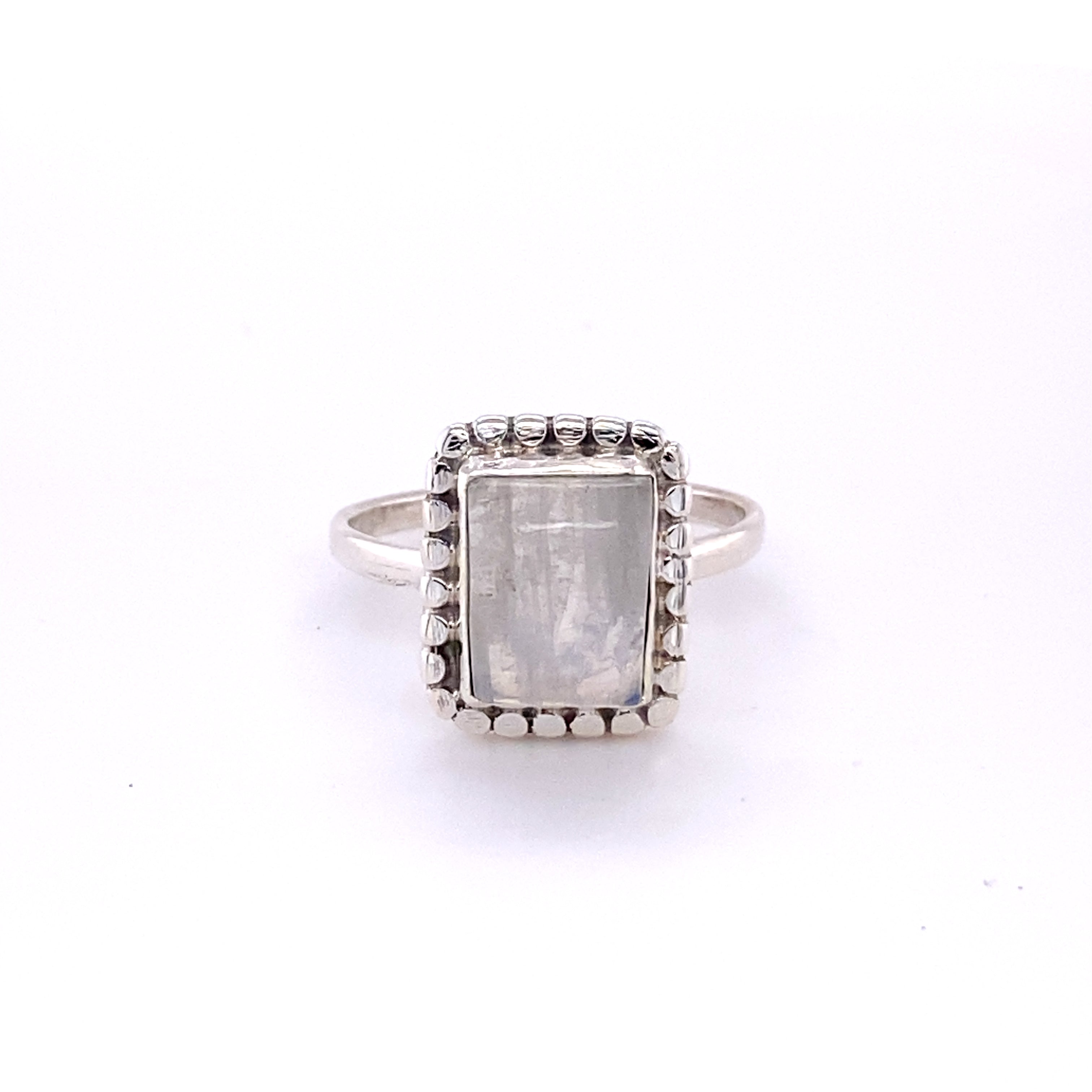 A square ring with natural gemstones from Santa Cruz with a white stone in the center.
