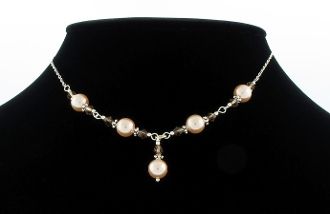 A Shell Pearl and Smokey Quartz Necklace adorned with champagne shell pearls on a mannequin by Super Silver.