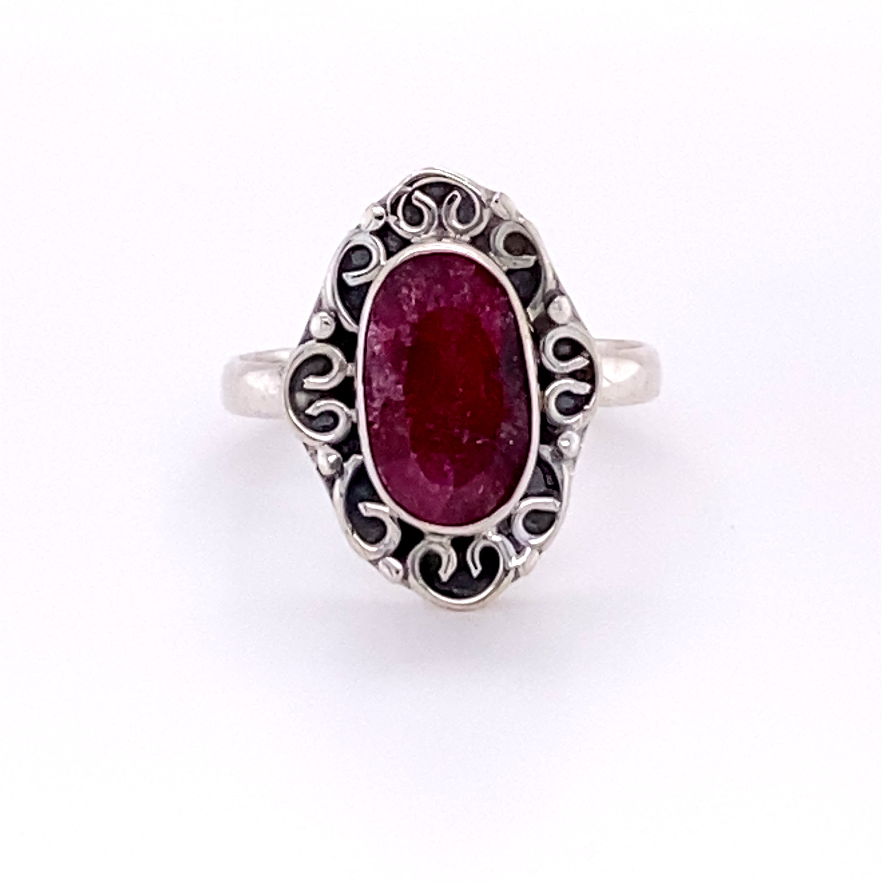 An Oval Gemstone Ring with Swirl Filigree Border.