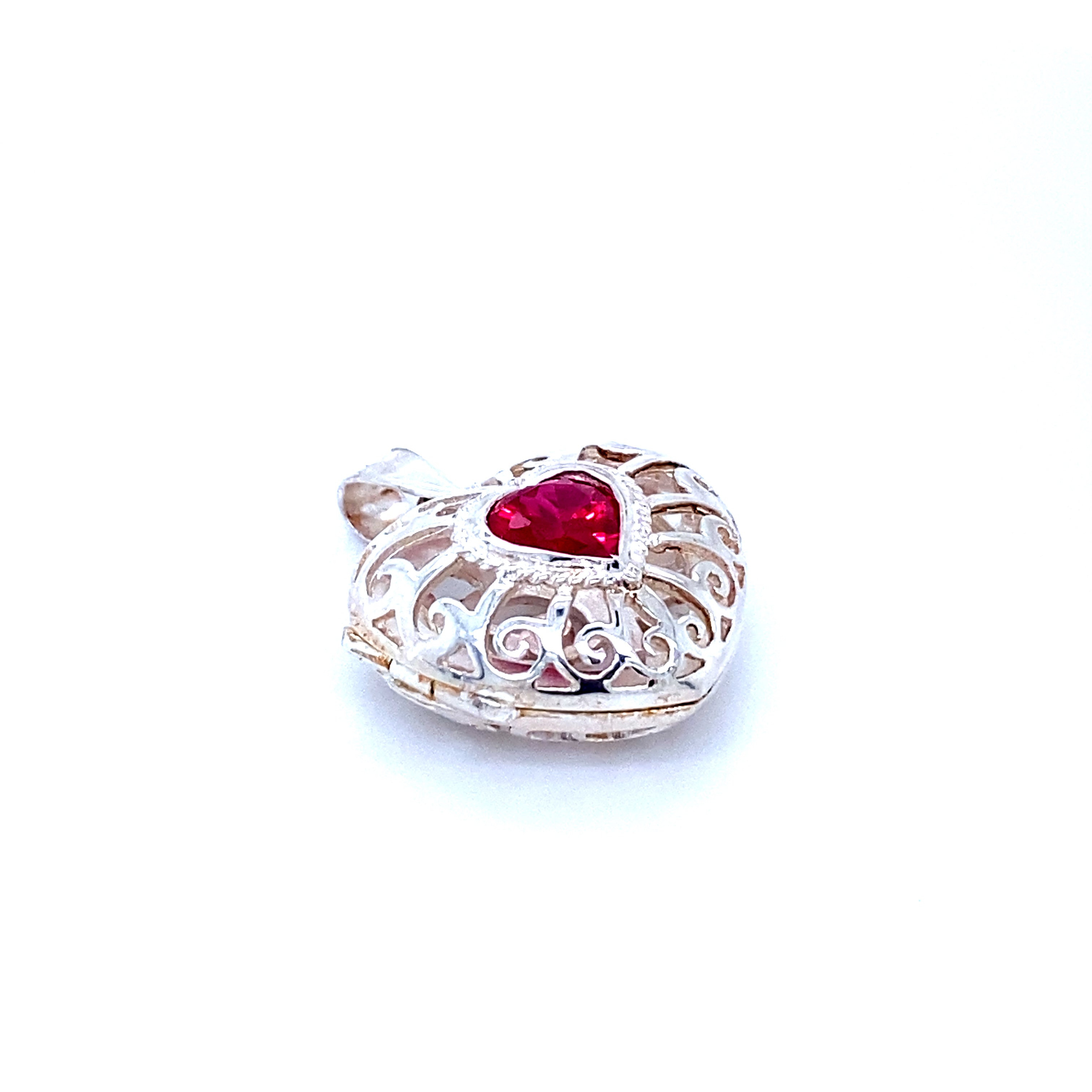 A Super Silver Heart Cage Locket With Cubic Zirconia Stones with a red stone and a delicate filigree design.