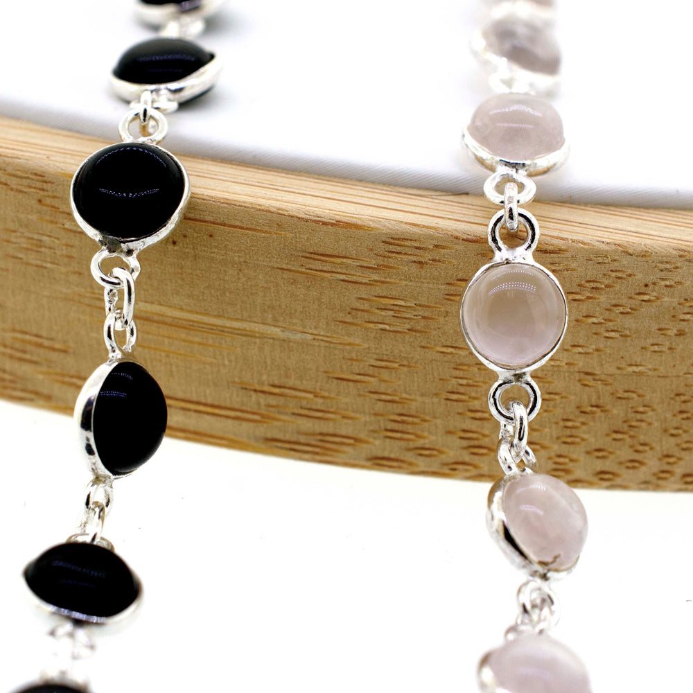 A delicate Super Silver bracelet adorned with round black and white gemstone stones, exuding an elegant touch of minimalism.