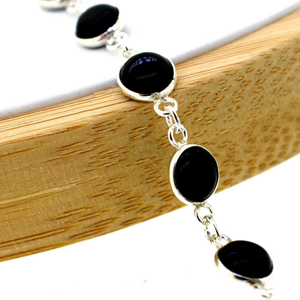 
                  
                    A delicate Simple Round Gemstone Bracelet With Delicate Wire Setting adorned with round black gemstones, exuding a minimalistic aesthetic, by Super Silver.
                  
                