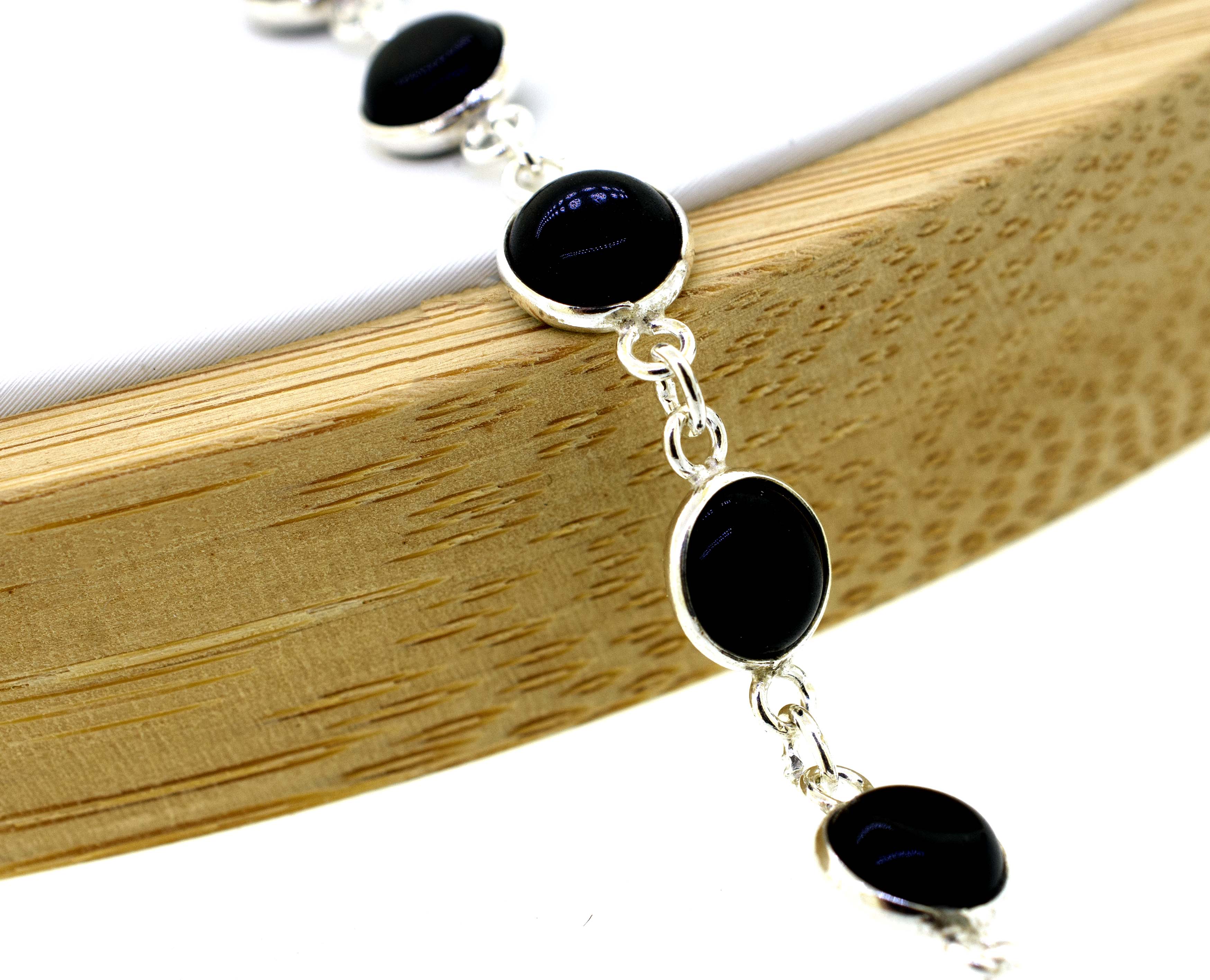 A delicate Simple Round Gemstone Bracelet With Delicate Wire Setting adorned with round black gemstones, exuding a minimalistic aesthetic, by Super Silver.