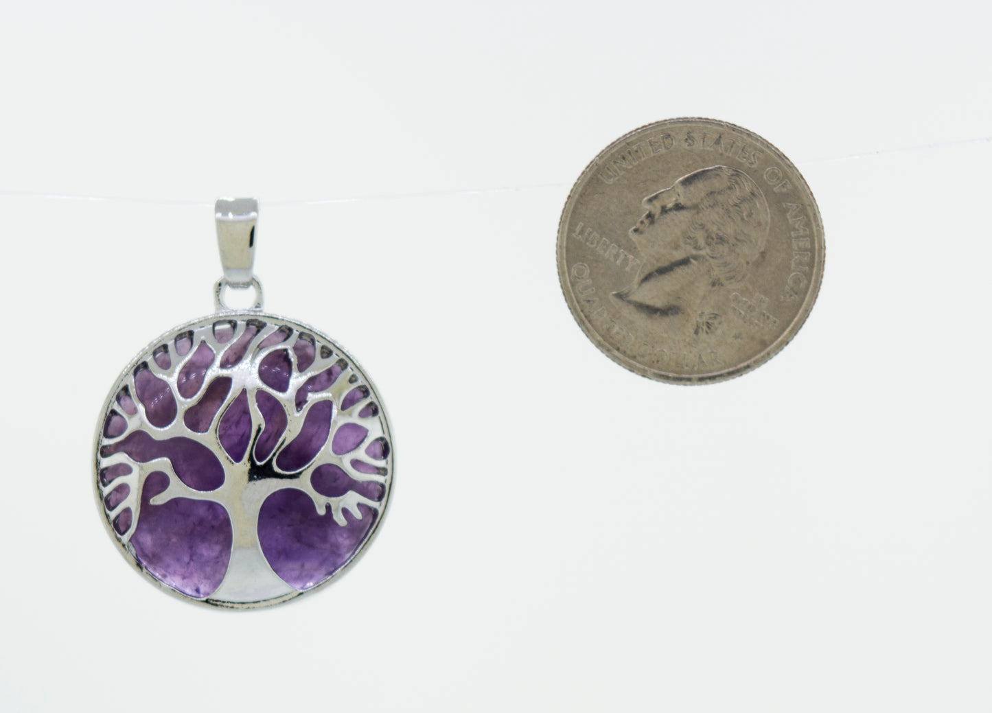 A beautiful Super Silver Tree of Life pendant adorned with a round purple stone.