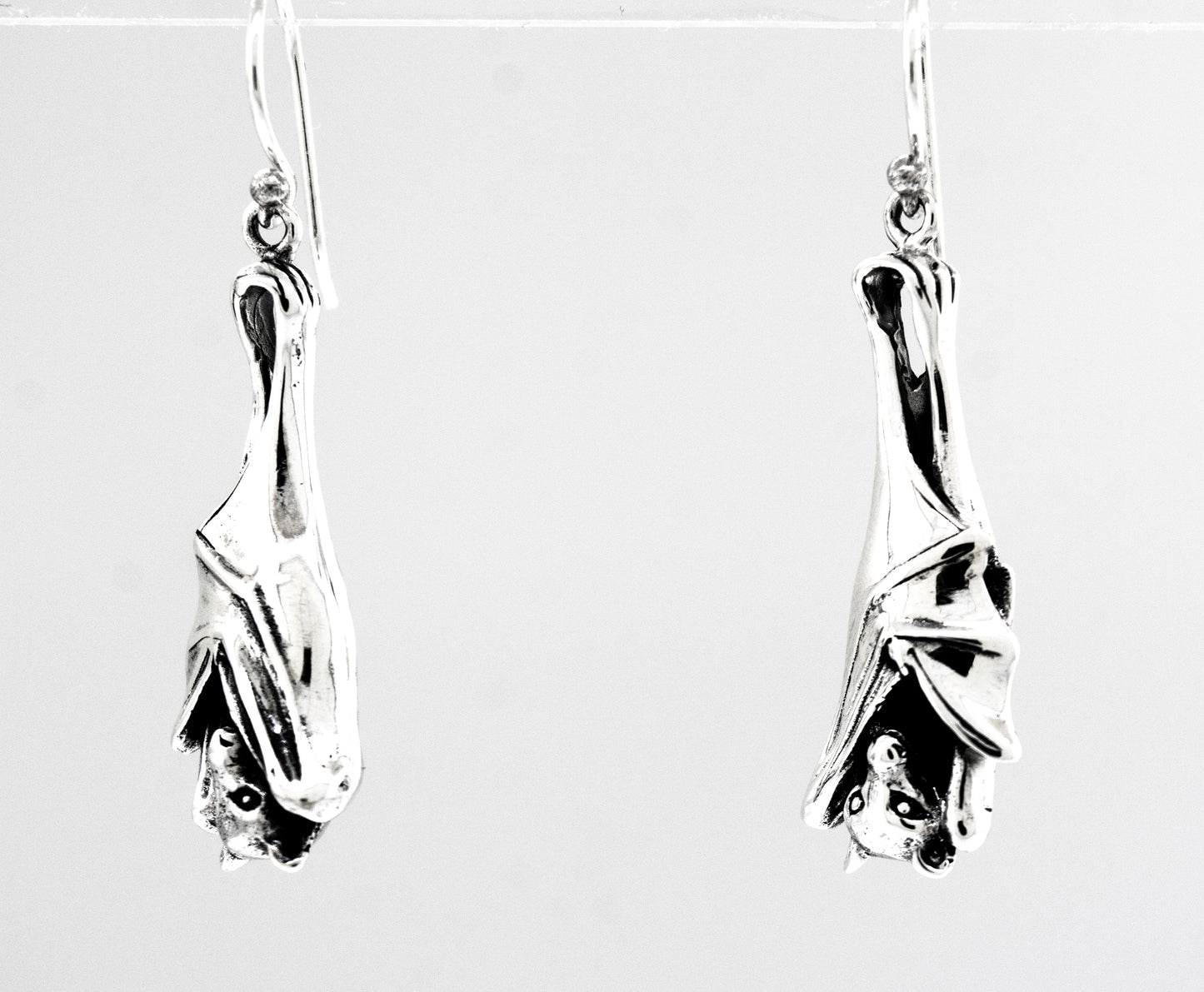 A pair of Super Silver Designer Bat Dangle Earrings.