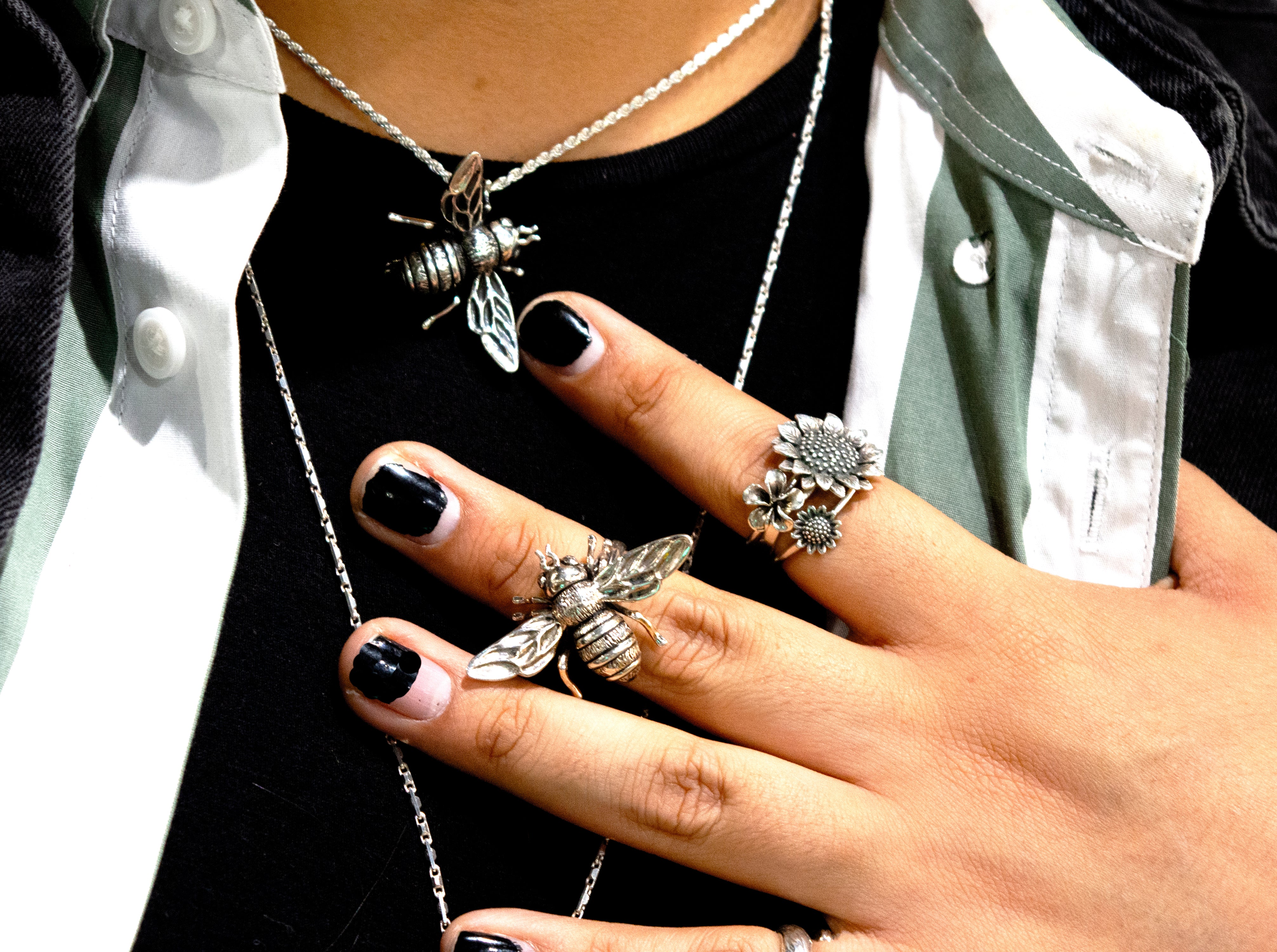 A woman wearing a beautiful Super Silver Stunning Sterling Silver Bee Pendant from the Artisan Collections.