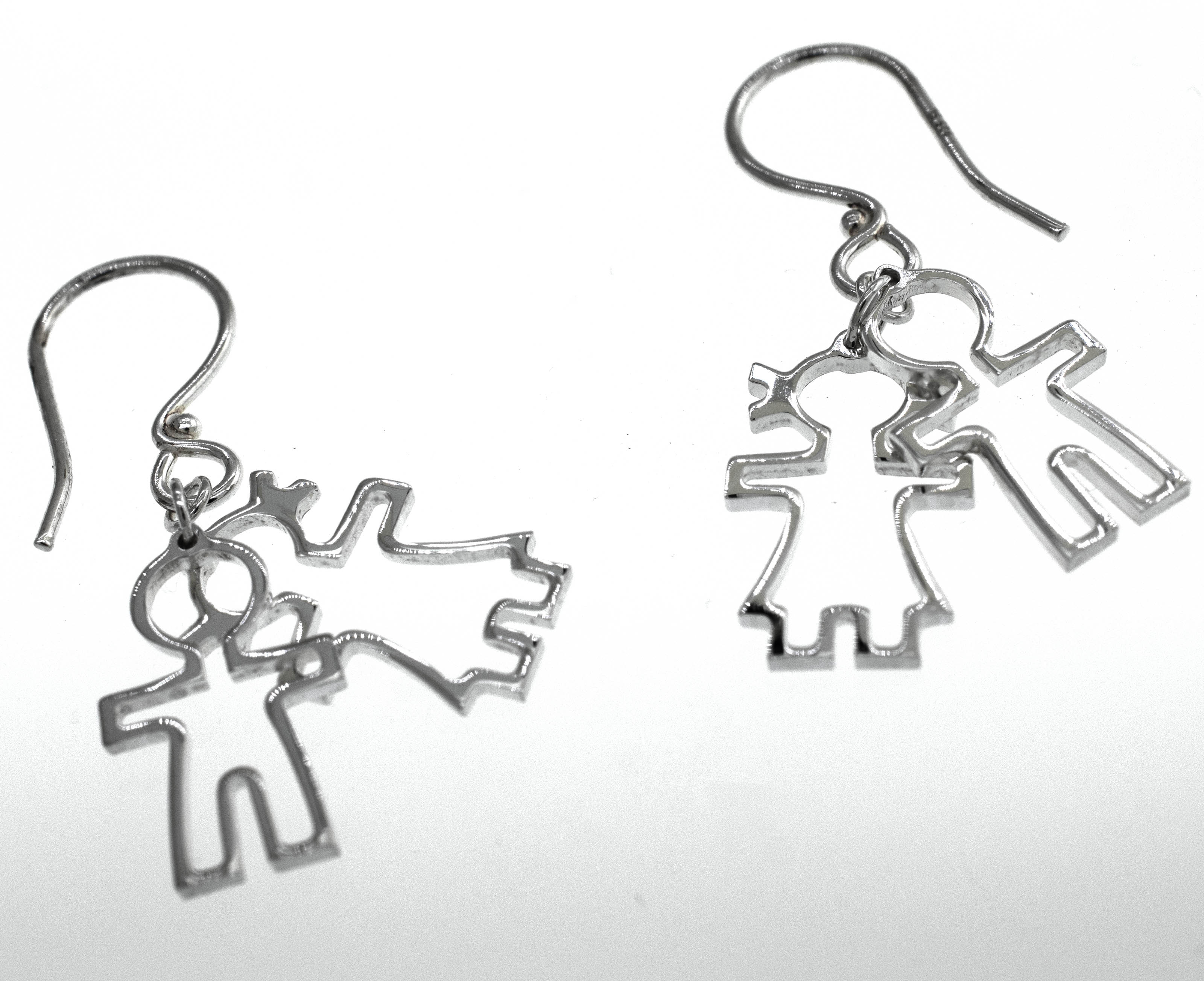A pair of Super Silver Little Humans Earrings, depicting two people, embodying love and humanity.