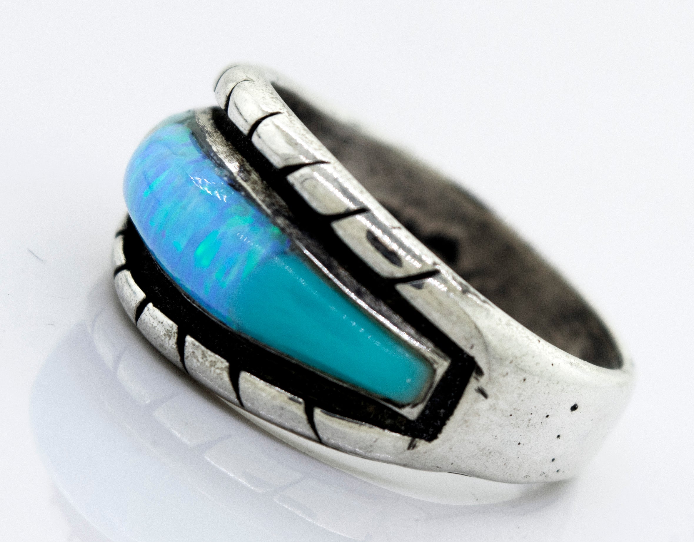 A Super Silver American Made Opal Inlay Ring with a blue opal stone in it.