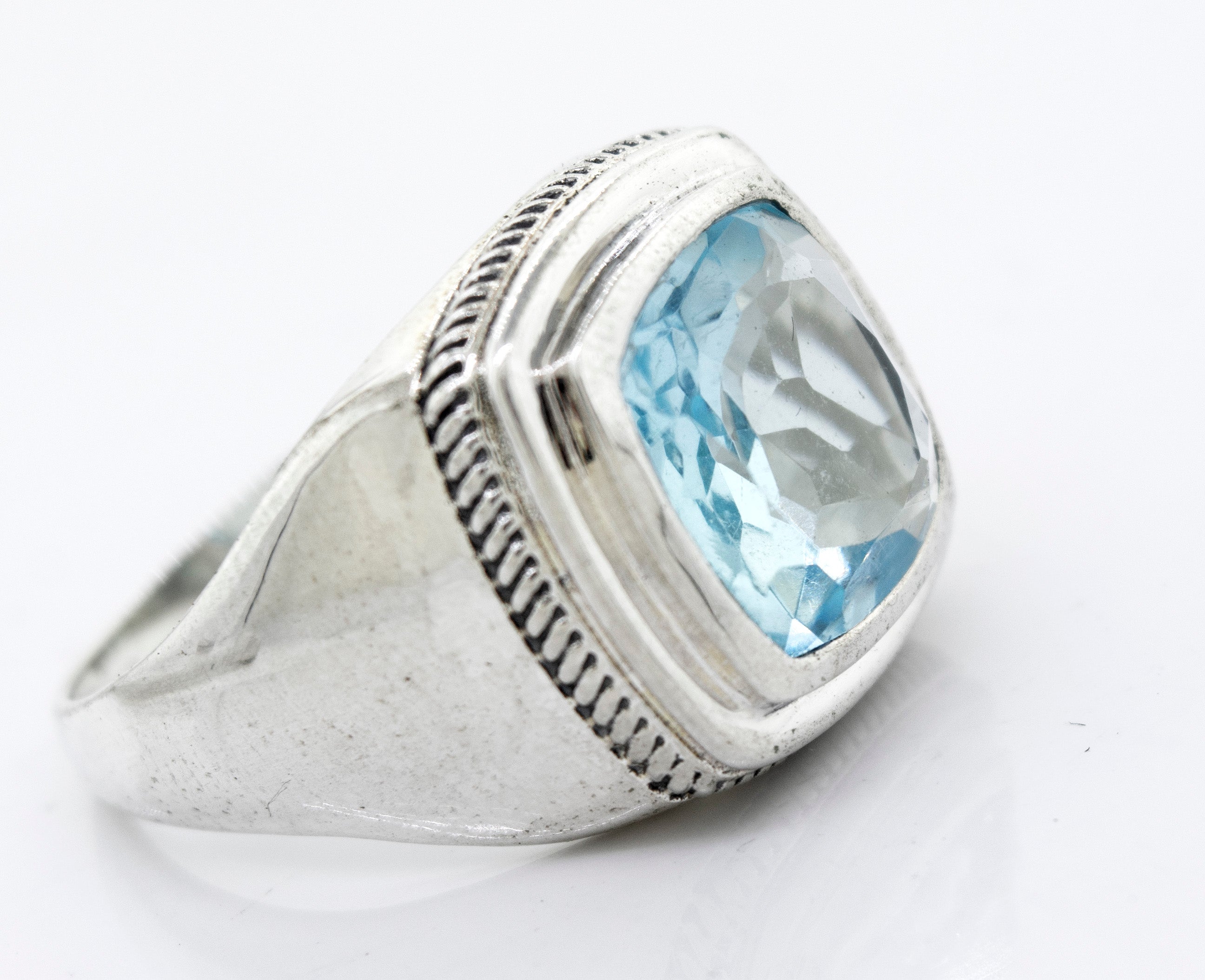 A Faceted Stone Signet Ring with a rectangular blue topaz gemstone set in a faceted cut on a white background.