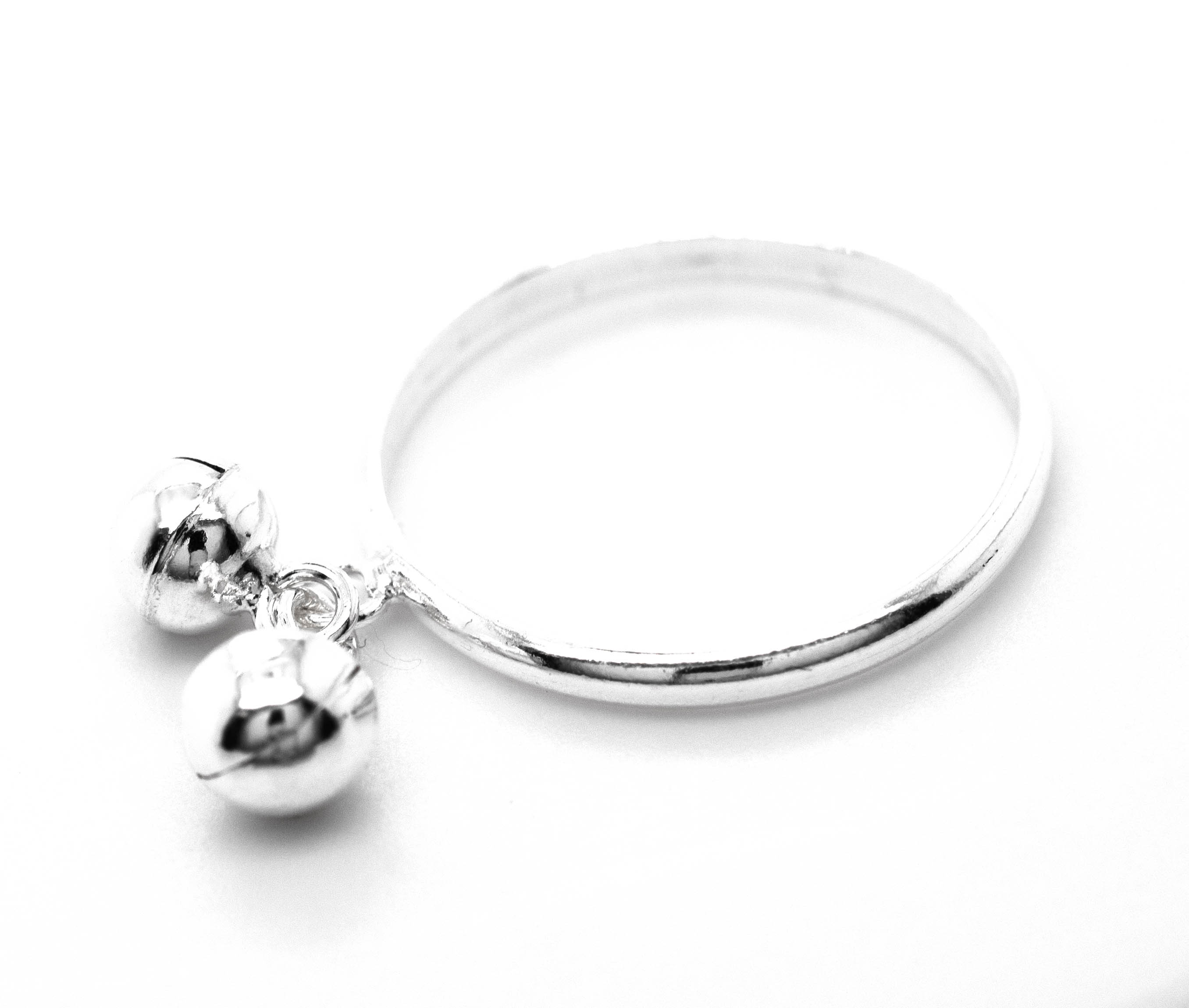 A Delicate Charm Ring with Bells adorned with silver balls and branded by Super Silver.