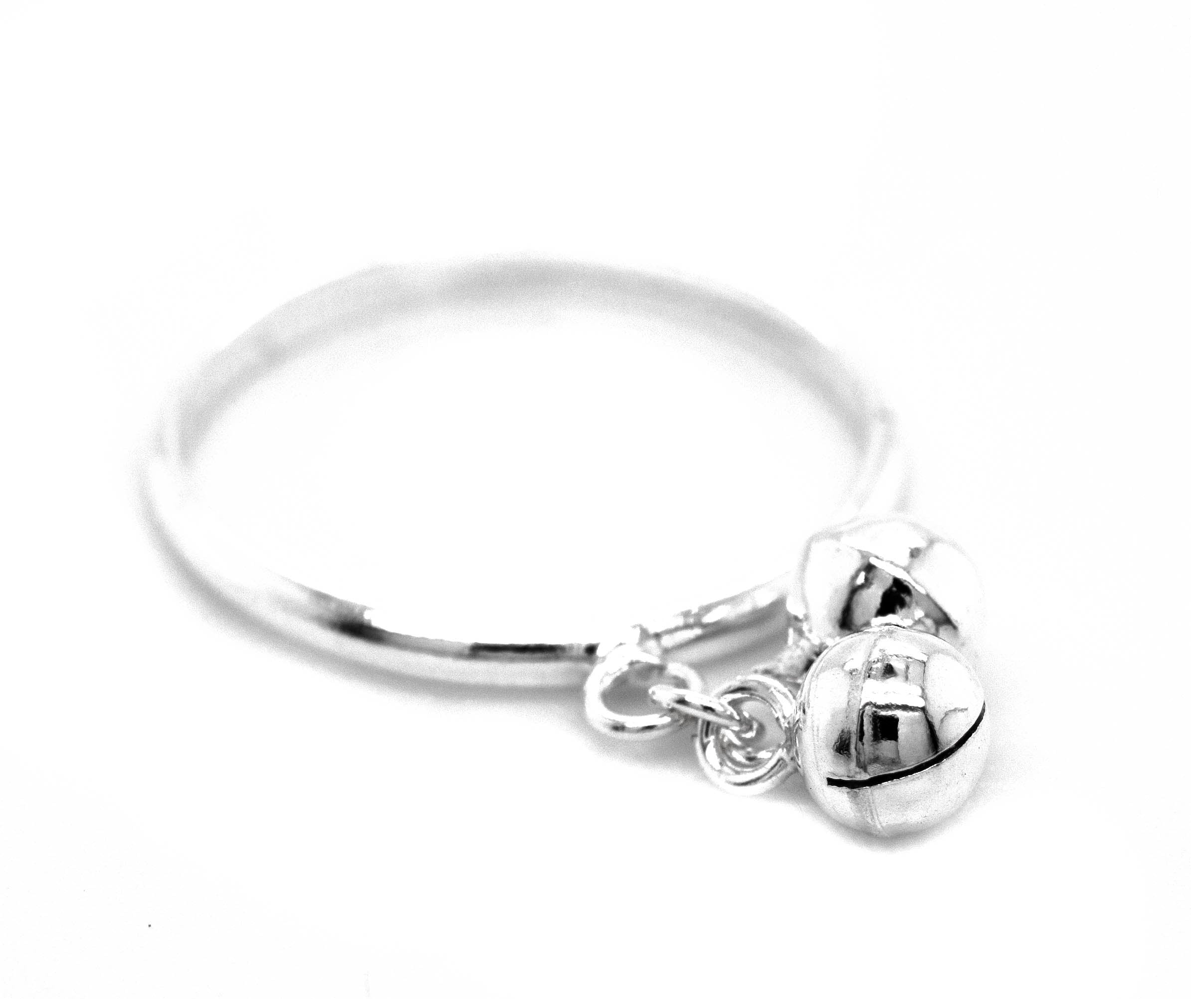 A Delicate Charm Ring with Bells from Super Silver featuring two silver balls.