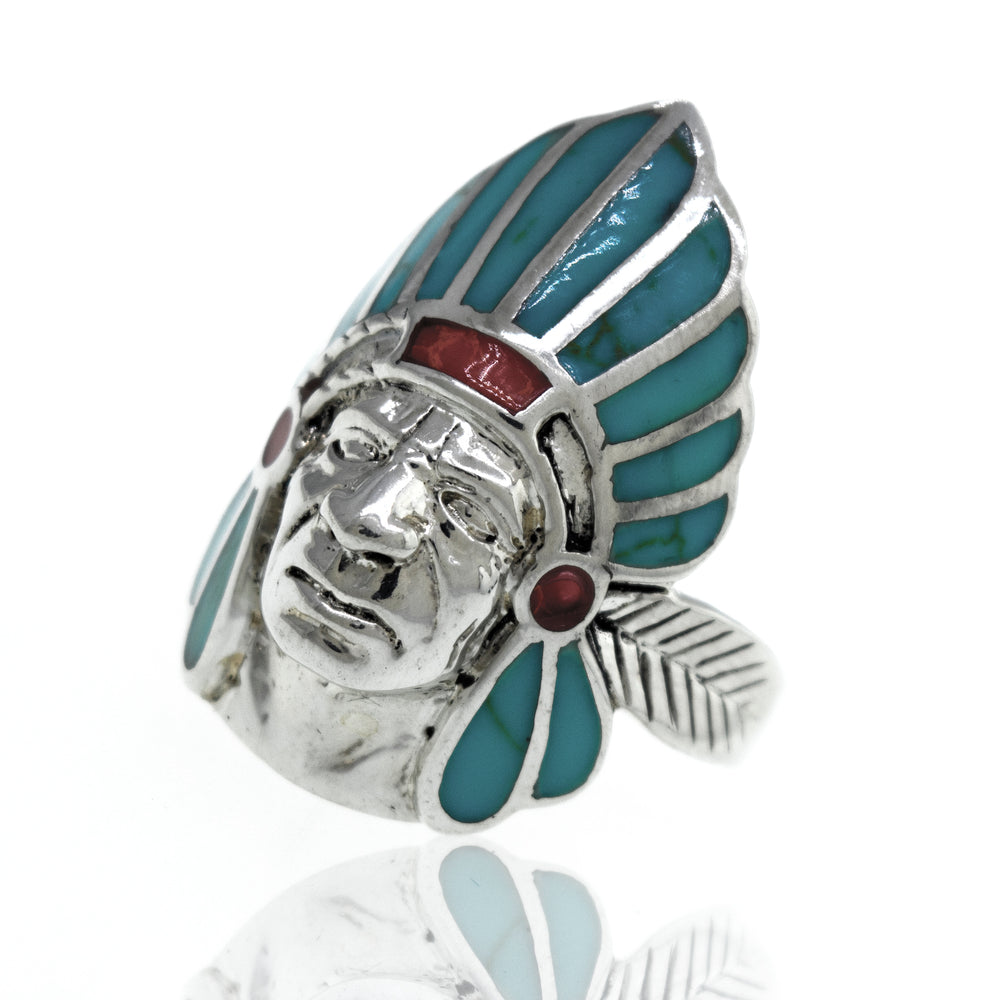 
                  
                    A sterling silver Turquoise And Coral Chief Head ring with turquoise and red stones.
                  
                