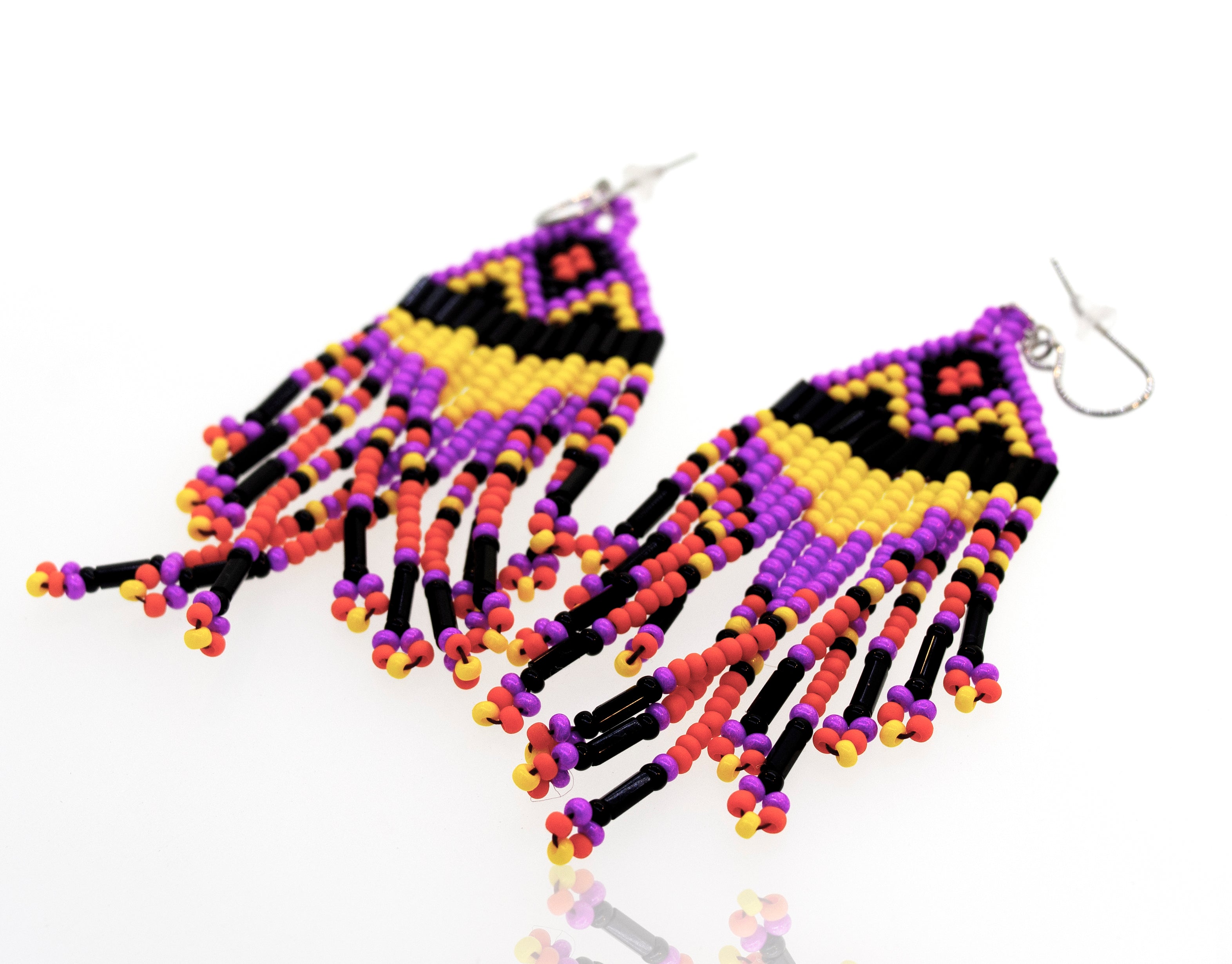 A pair of Super Silver southwest inspired earrings with gemstone beads on a white surface.