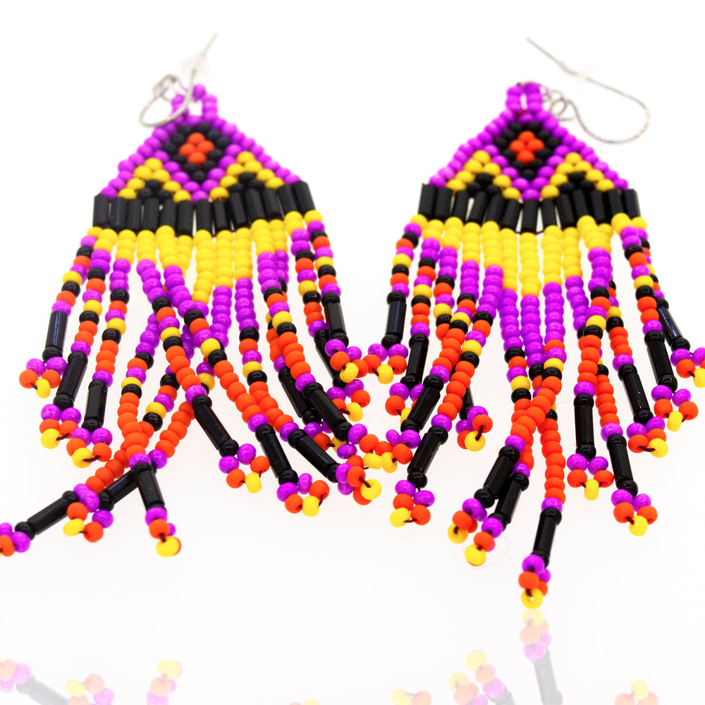 A pair of Super Silver southwest-inspired earrings with purple and yellow gemstone beads, displayed on a white surface.