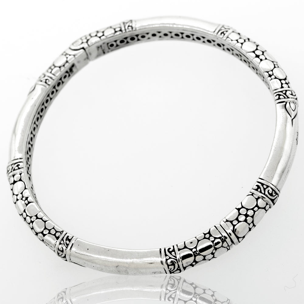 
                  
                    A Super Silver sterling silver handmade designer bangle with an intricate bubble design and latch mechanism.
                  
                
