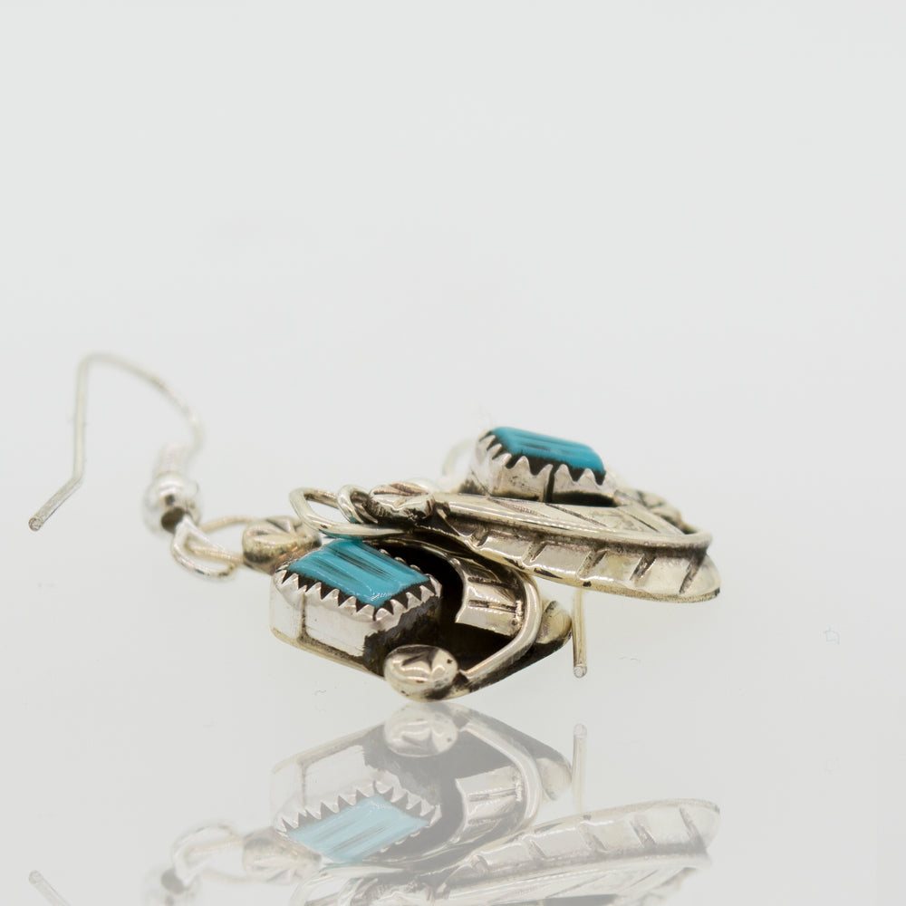 A pair of Zuni Handmade Turquoise Earrings by Super Silver with natural turquoise stones in a leaf design.