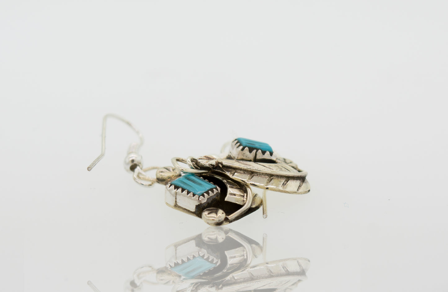 A pair of Zuni Handmade Turquoise Earrings by Super Silver with natural turquoise stones in a leaf design.