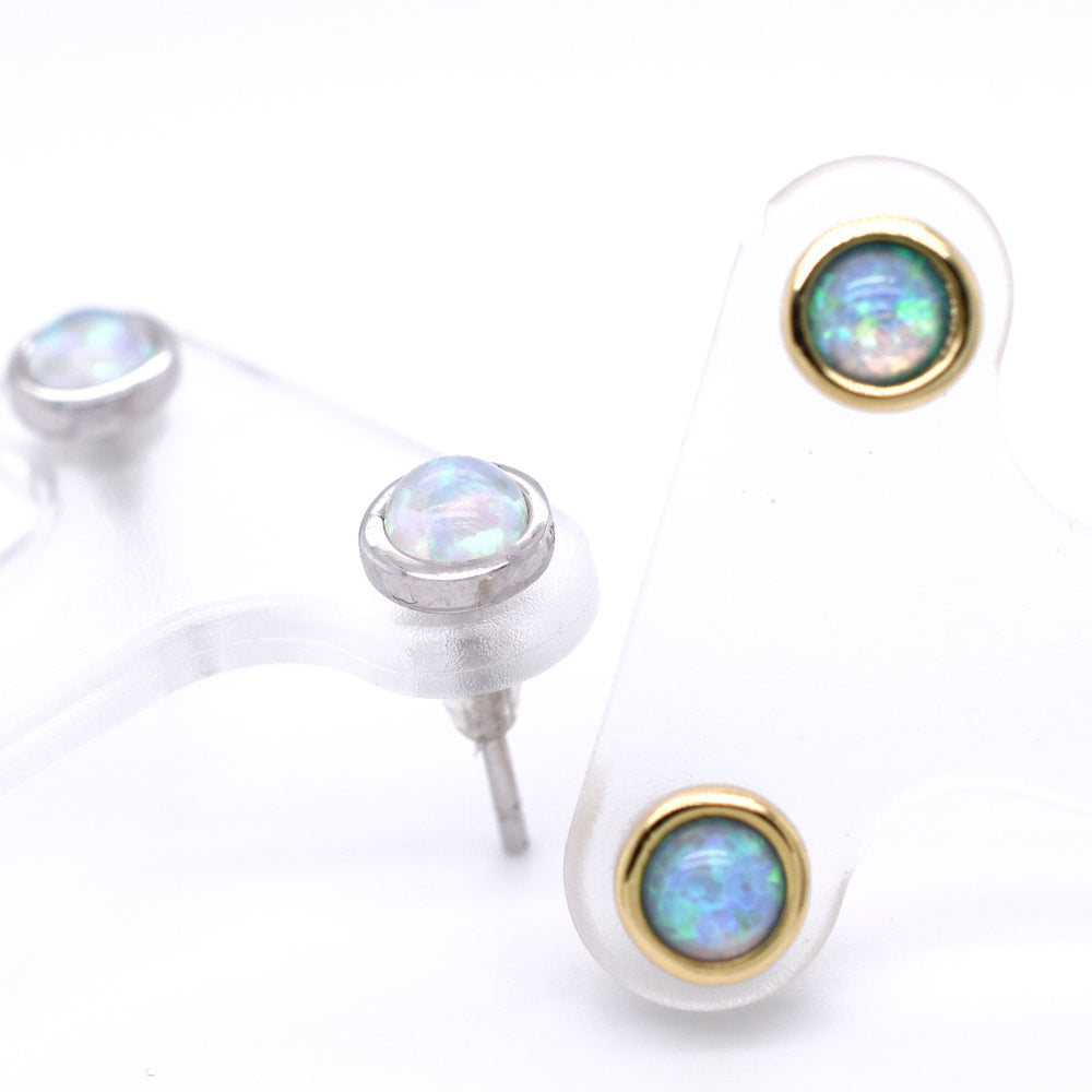 A pair of Radiant Australian Opal Studs by Super Silver, showcasing brilliant colors, on a white surface.