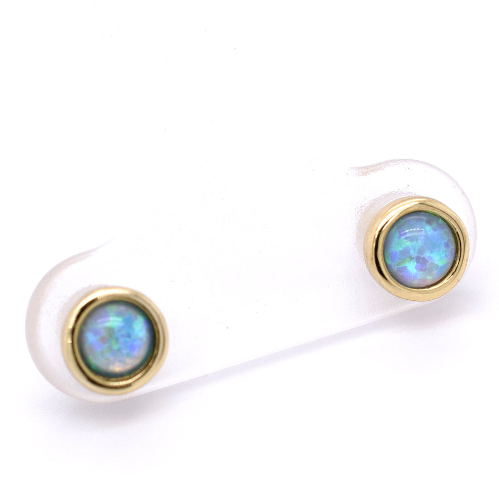 A pair of Super Silver Radiant Australian Opal Studs in brilliant blue on a white background.