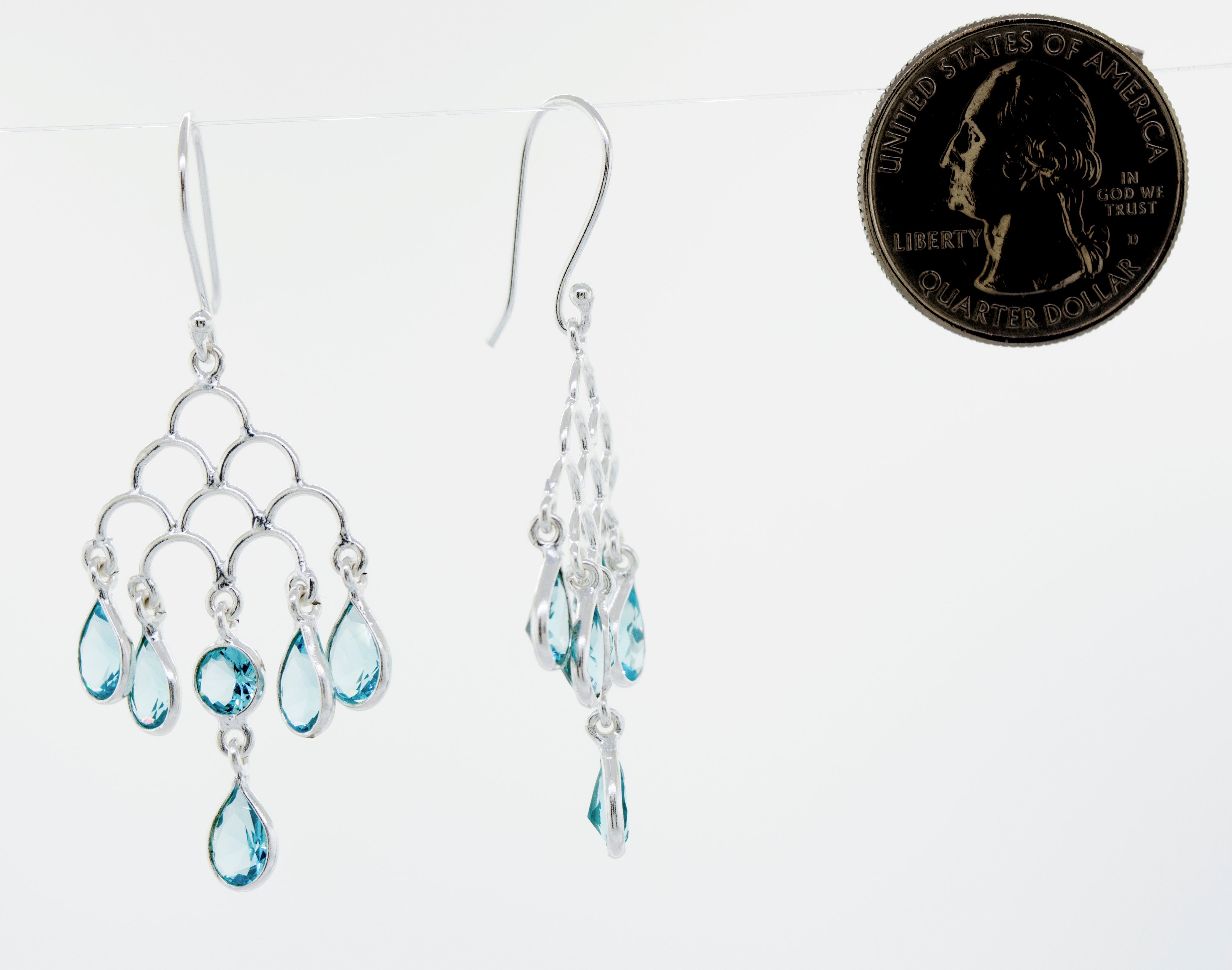These stunning Faceted Ruby Chandelier Earrings feature a vibrant blue topaz gemstone set in elegant Super Silver.