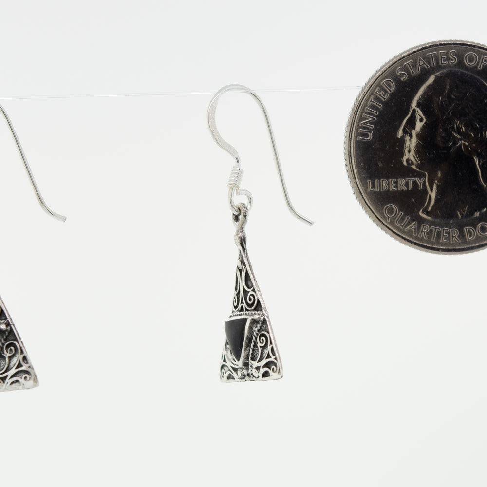 A Super Silver freestyle pair of Freestyle Design Triangle Shape Onyx Earrings accented with a silver penny in front.