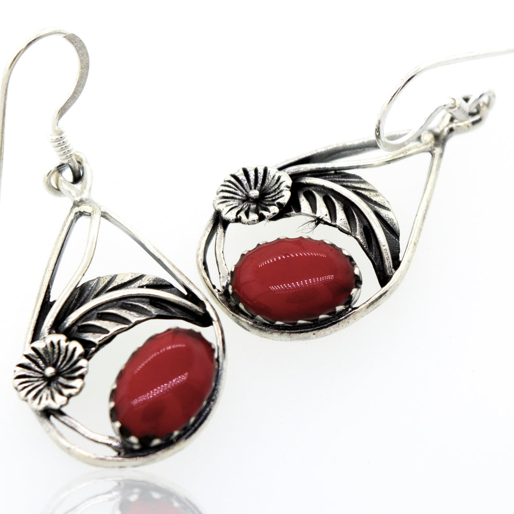 These Red Coral Teardrop Earrings With Floral Setting are crafted from high-quality sterling silver and feature vibrant red coral accents. They are from the Super Silver brand.