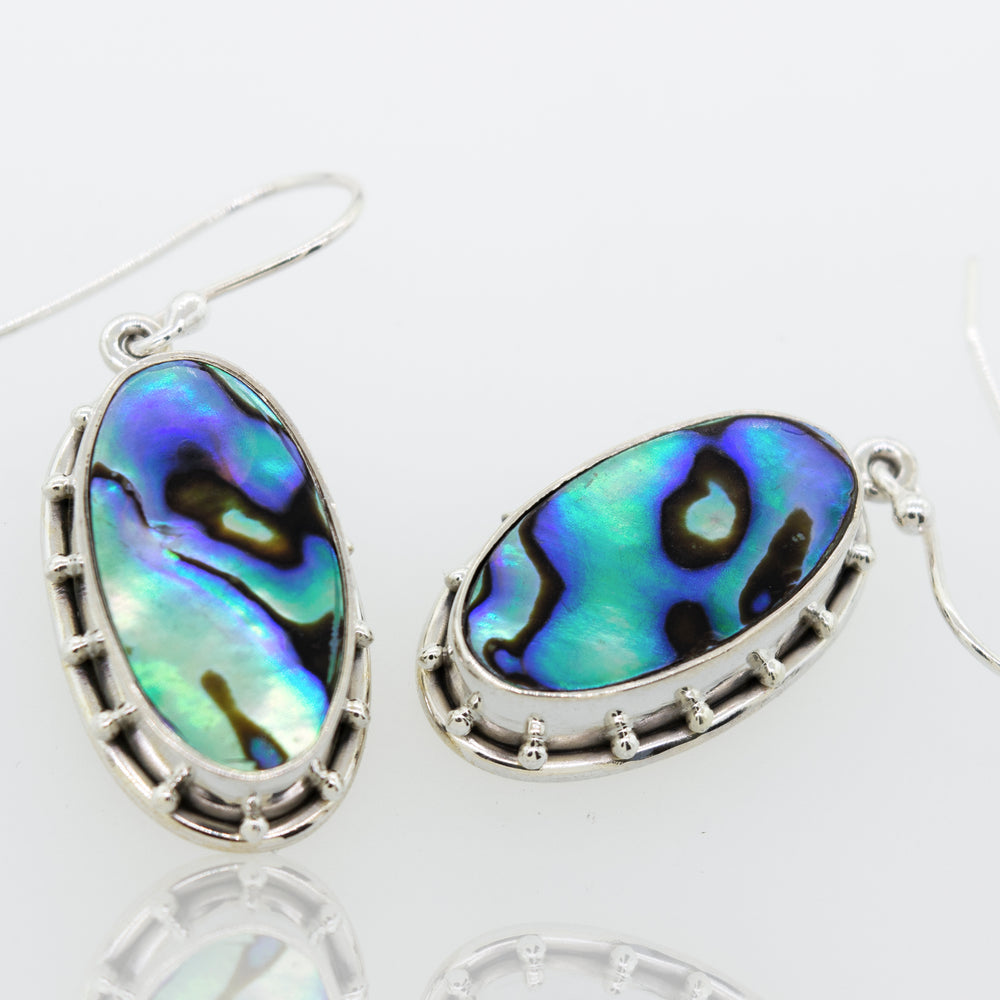 Super Silver Oval Abalone earrings on a white surface.