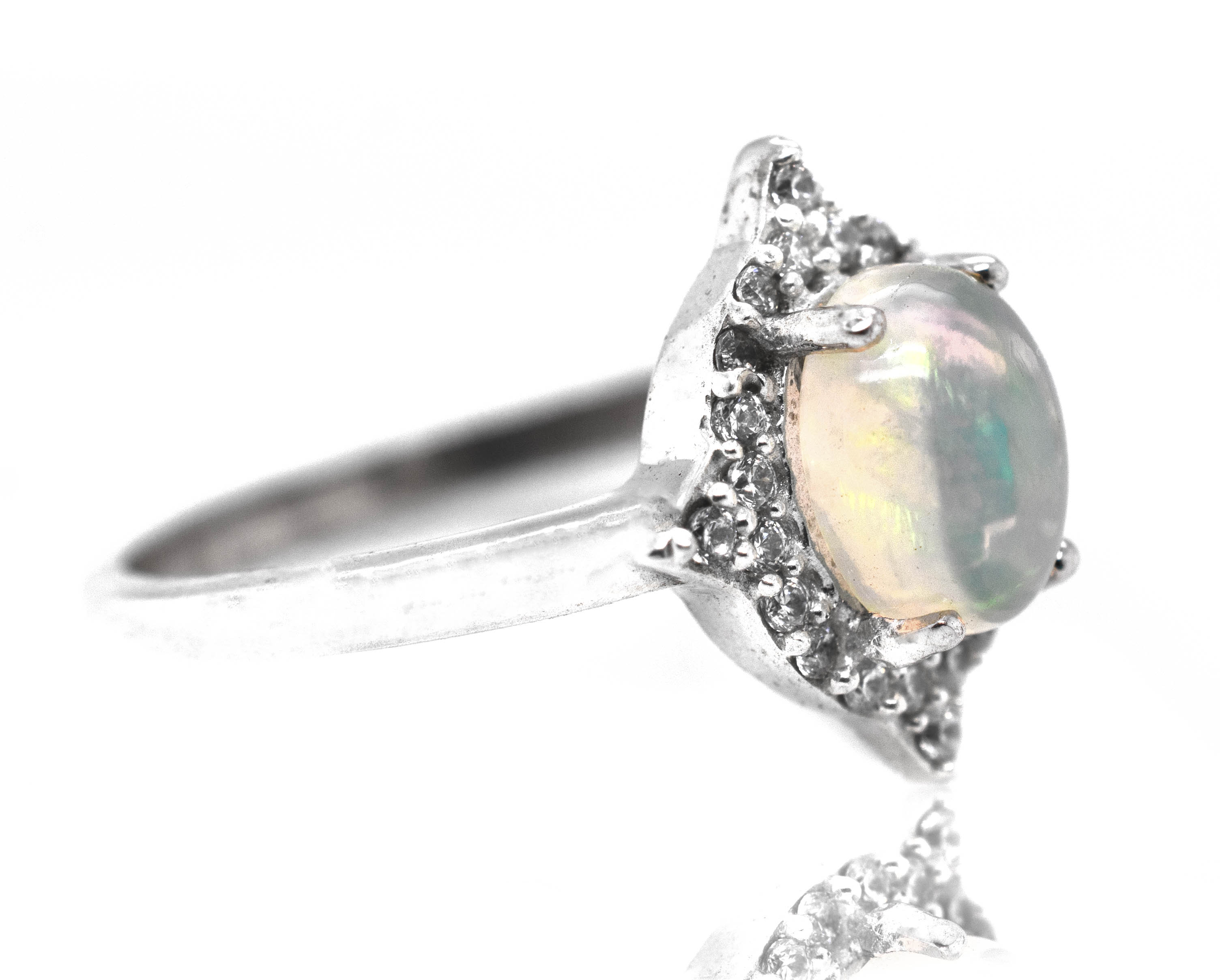 An elegant Elegant Ethiopian Opal Ring With Cubic Zirconia Stones on a white background.
