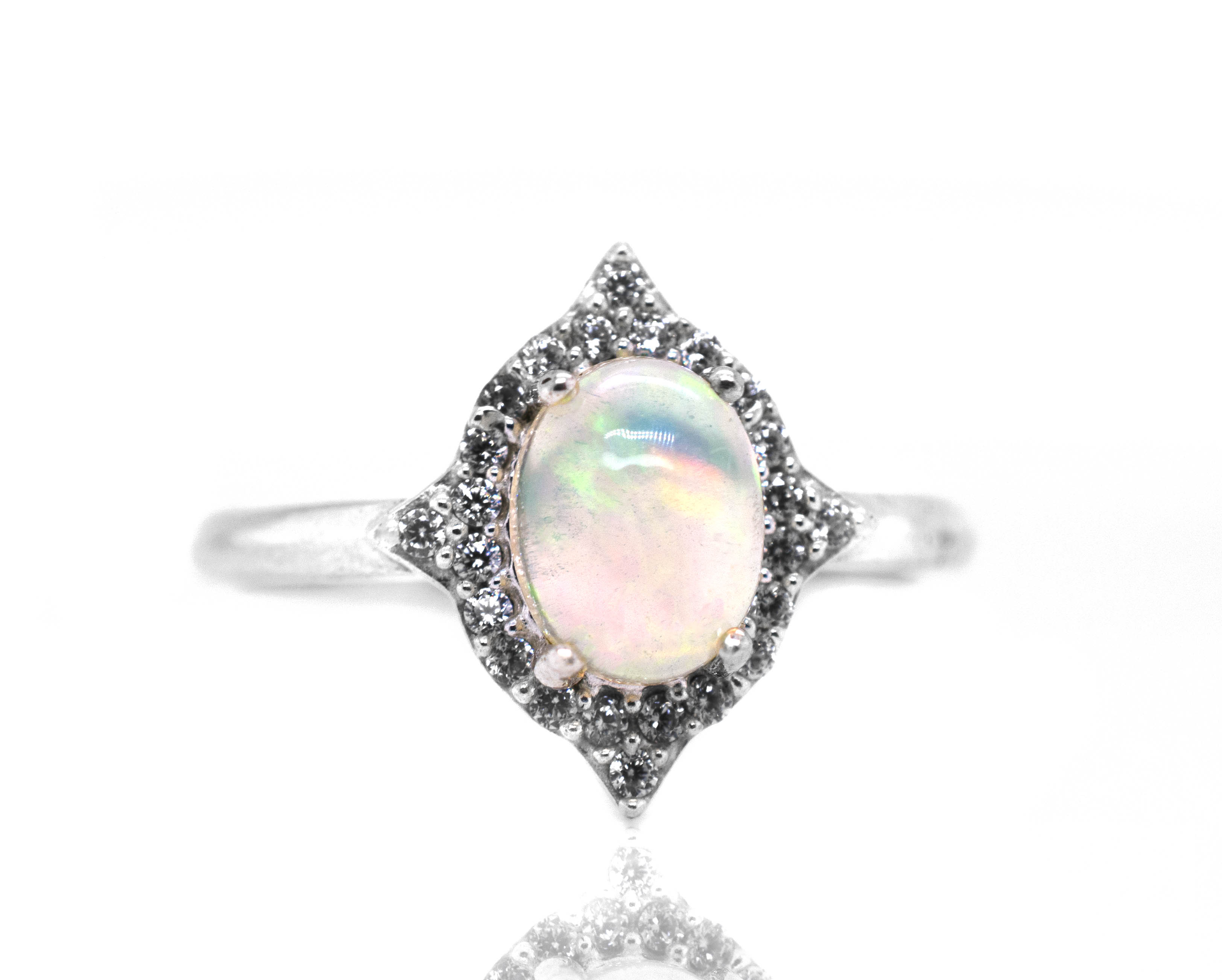 An elegant Elegant Ethiopian Opal Ring With Cubic Zirconia Stones on a white background.