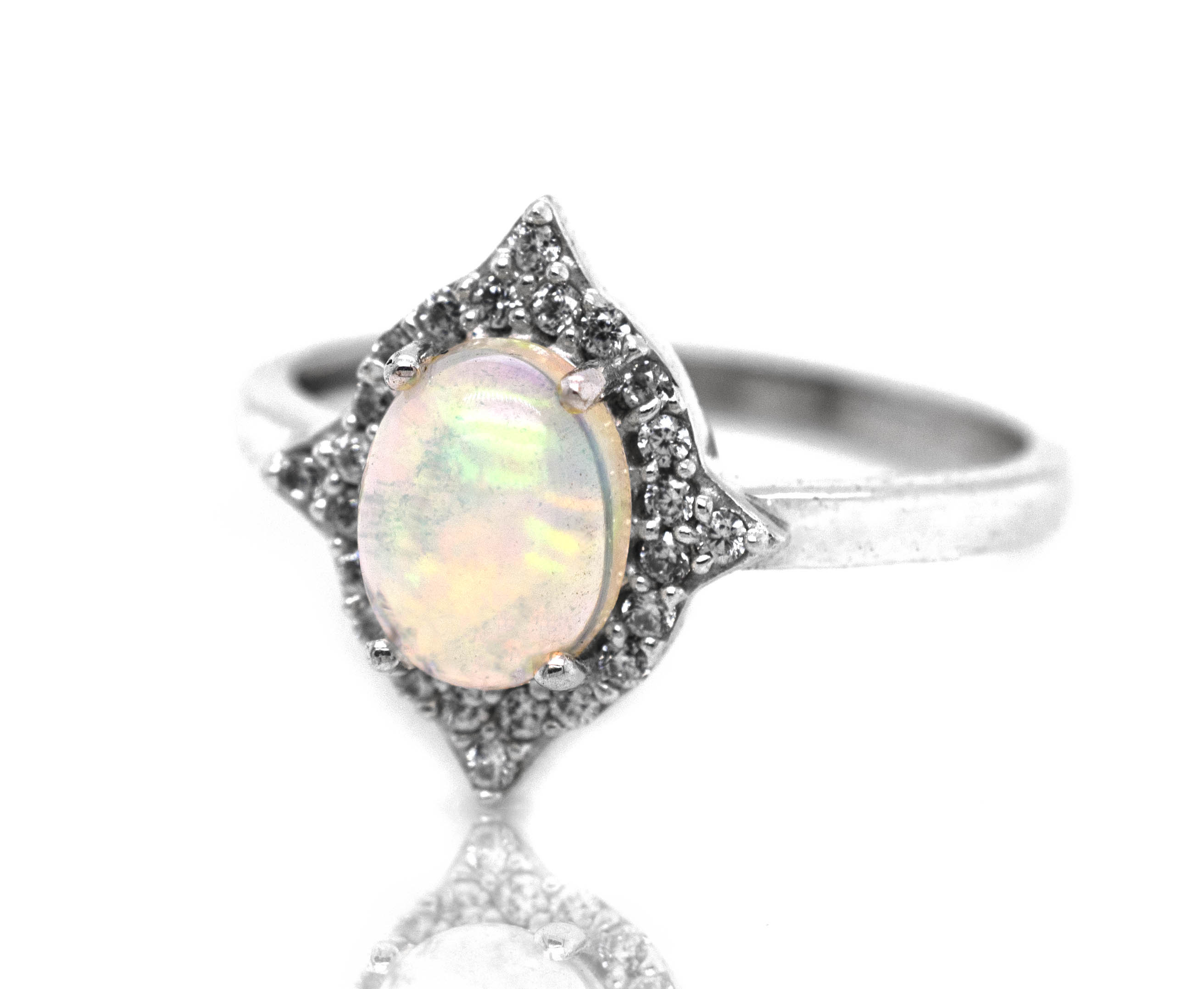 An Elegant Ethiopian Opal ring with Cubic Zirconia stones on a white background.