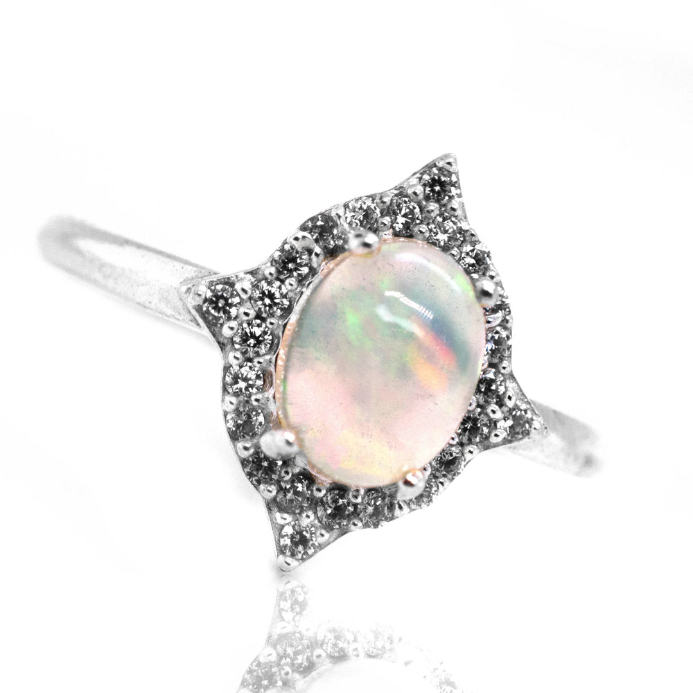 An Elegant Ethiopian Opal Ring With Cubic Zirconia Stones on a white background.
