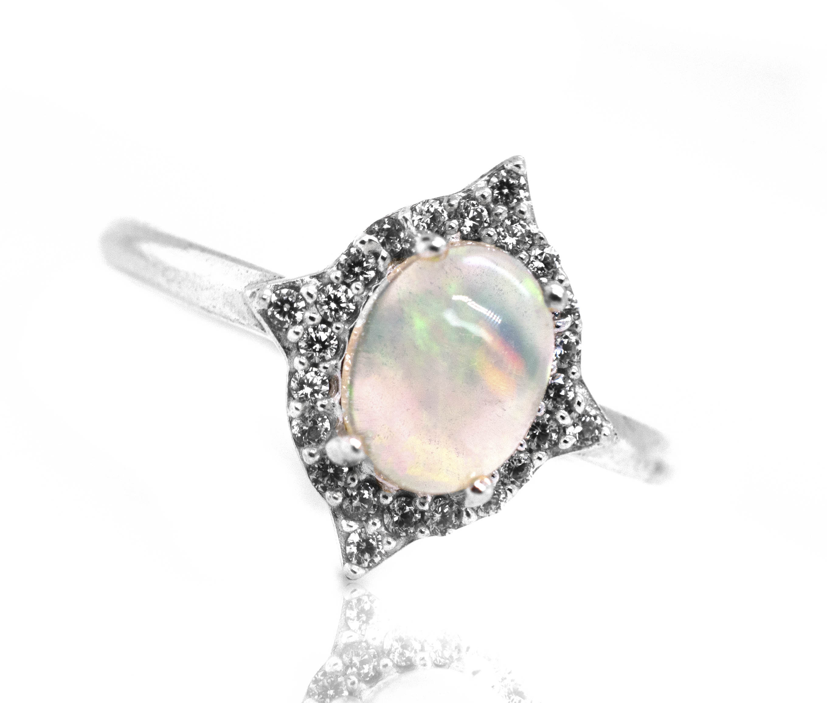 An Elegant Ethiopian Opal Ring With Cubic Zirconia Stones on a white background.