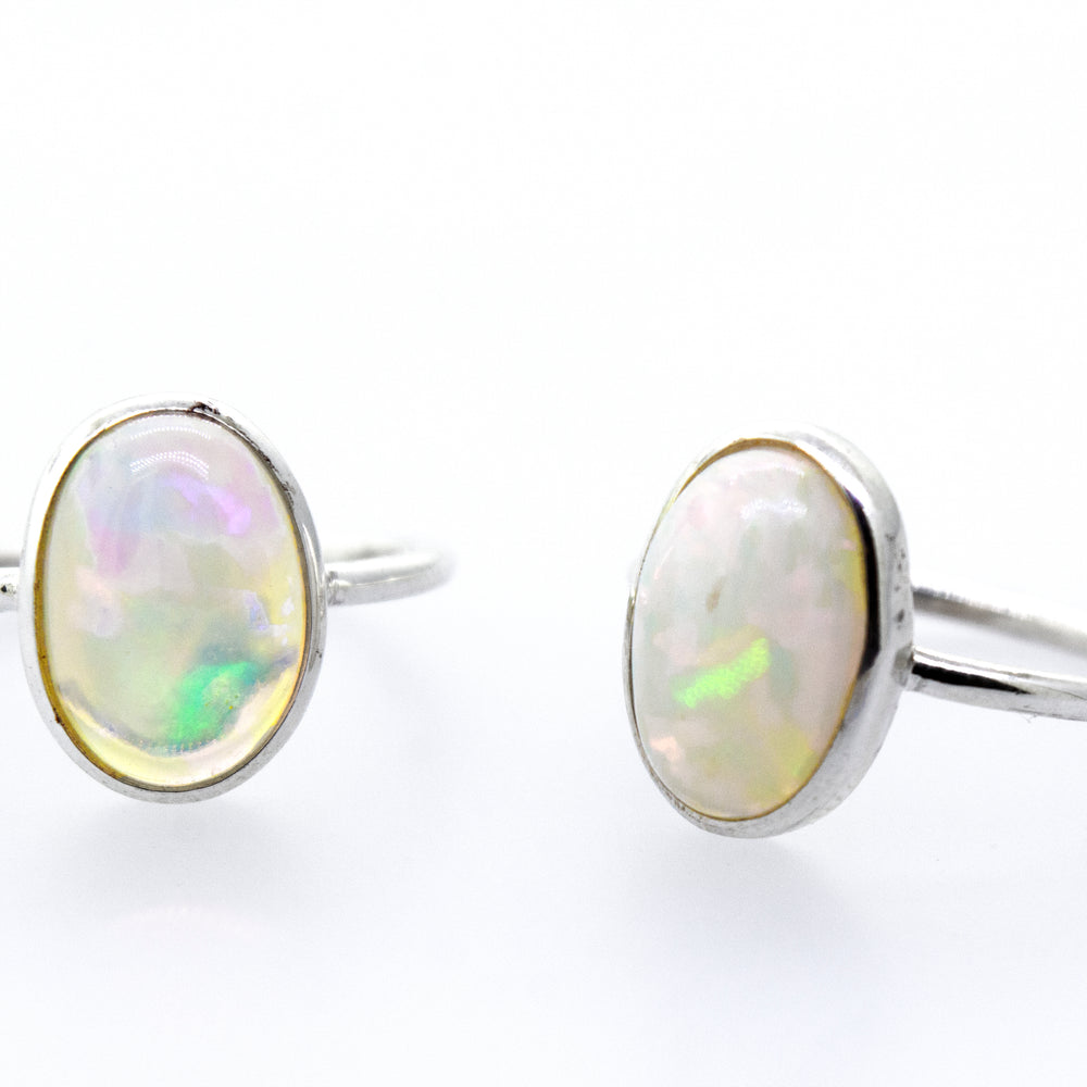 An elegant pair of Ethiopian Opal Ring with Oval Stone on a white background.