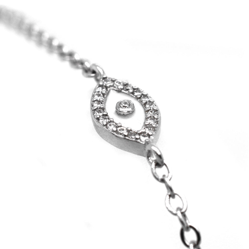 A Trendy Pave Cubic Zirconia Evil Eye Bracelet with a silver protective amulet adorned with cubic zirconia stones.