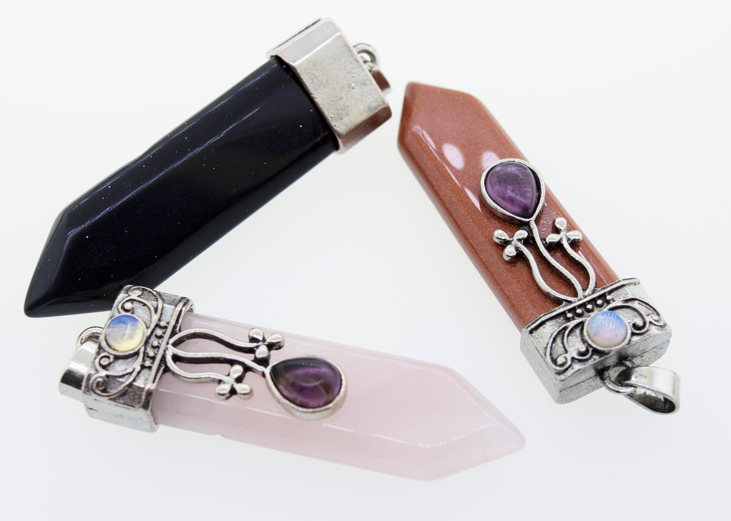 
                  
                    Three Obelisk Crystal Stone Pendants, each uniquely set in a Super Silver silver-plated setting, perfect for adding a touch of Boho style to any outfit.
                  
                