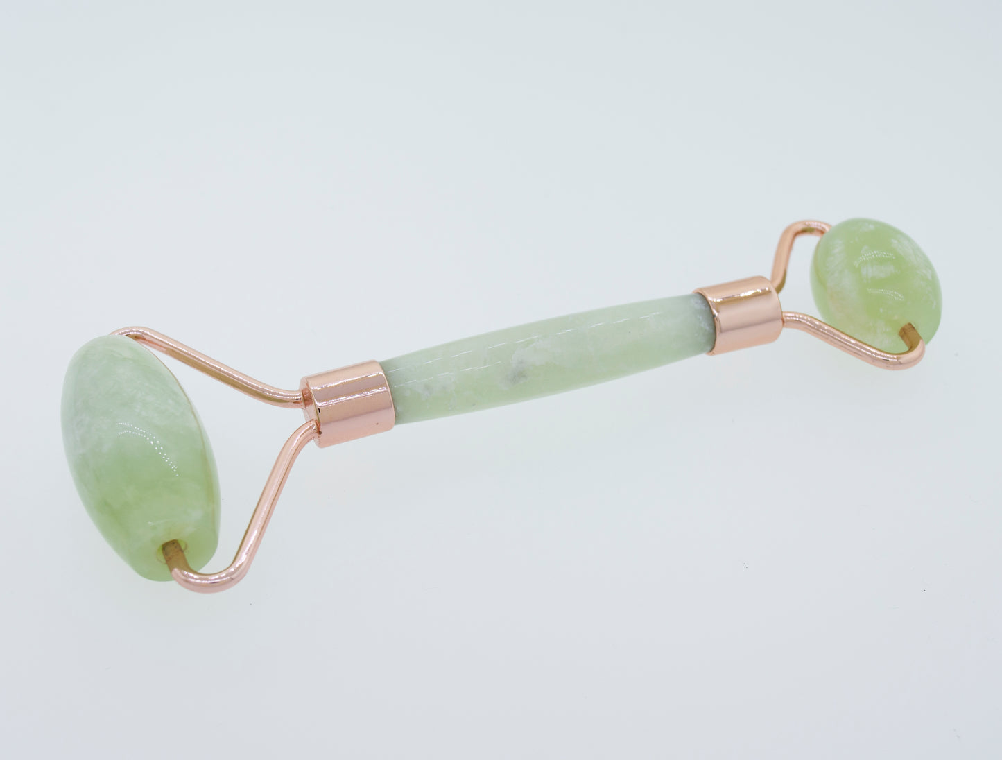 
                  
                    A green Stone Face-roller on a white surface, perfect for self care rituals.
                  
                