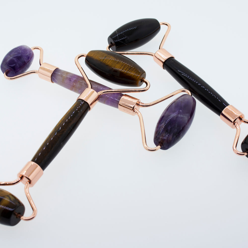 This description features Stone Face-rollers made of tiger eye, amethyst, and rose quartz stones. Incorporating the keywords "face roller" and "stone," it highlights these tools as part of a self-care.