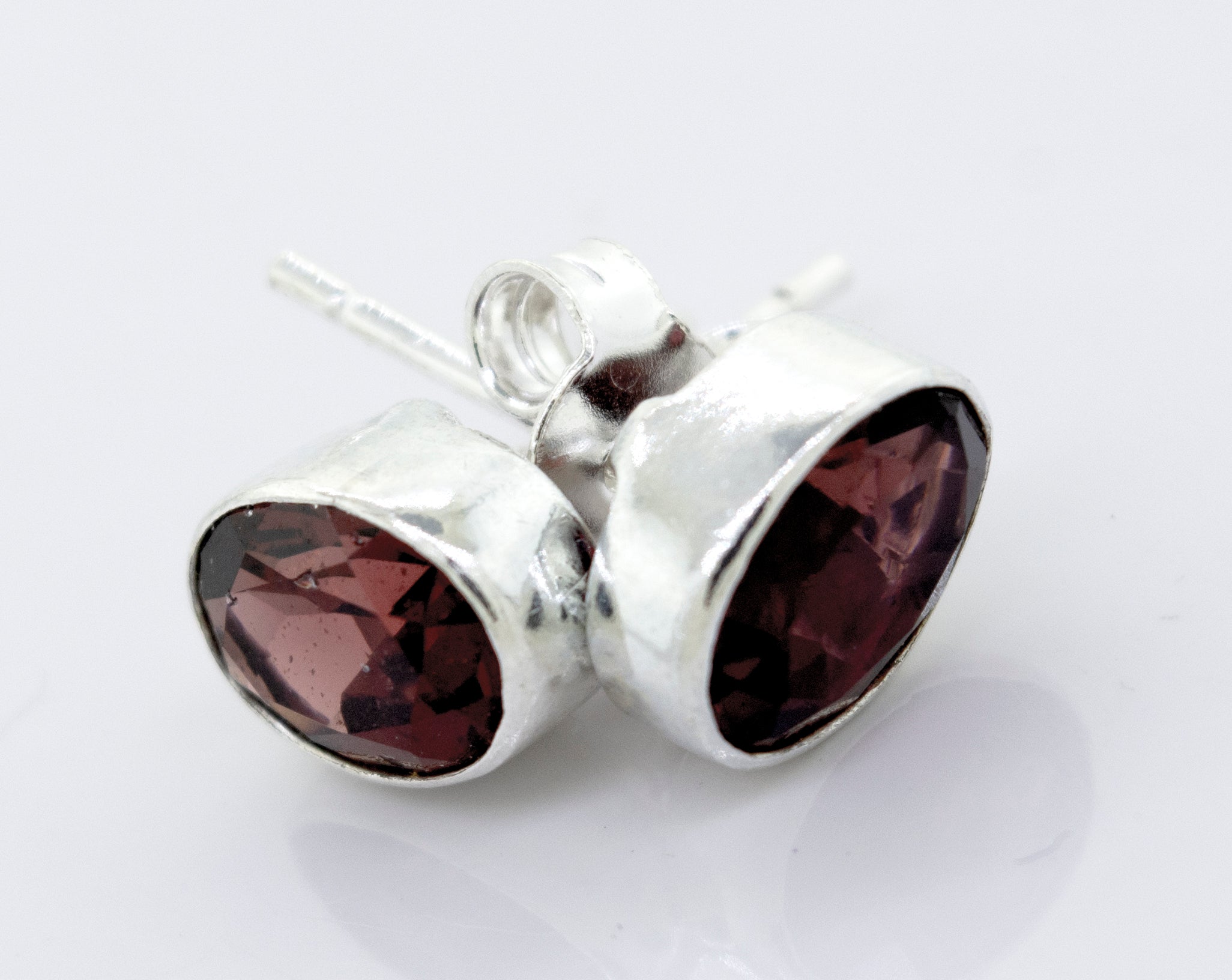 These Super Silver garnet studs with a plain sterling silver setting feature a faceted garnet stone in a sleek setting.