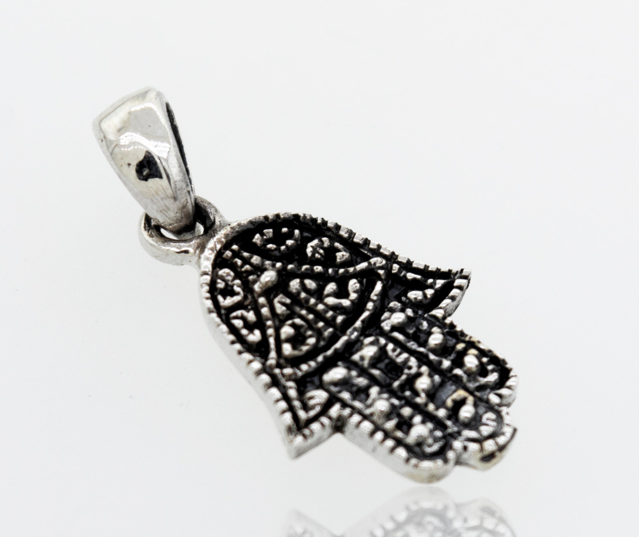 A Super Silver Small Hamsa Hand Pendant on a white surface.
